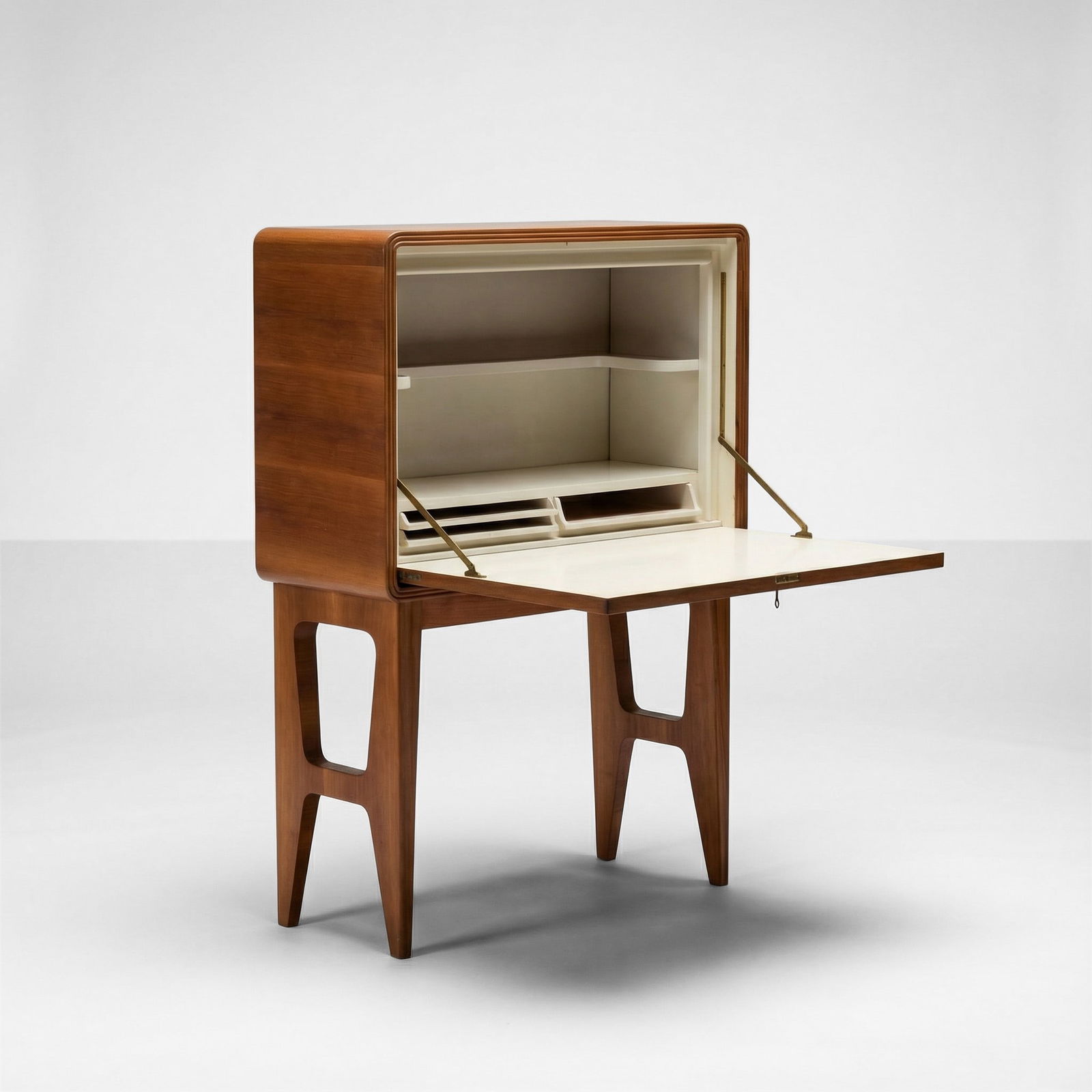 Mobile bar: Struttura e sostegni in legno. Anta a ribalta con decoro intarsiato in legno di diverse essenze. Interno in legno laccato e particolari in ottone. Prod. Italia, 1950 ca.