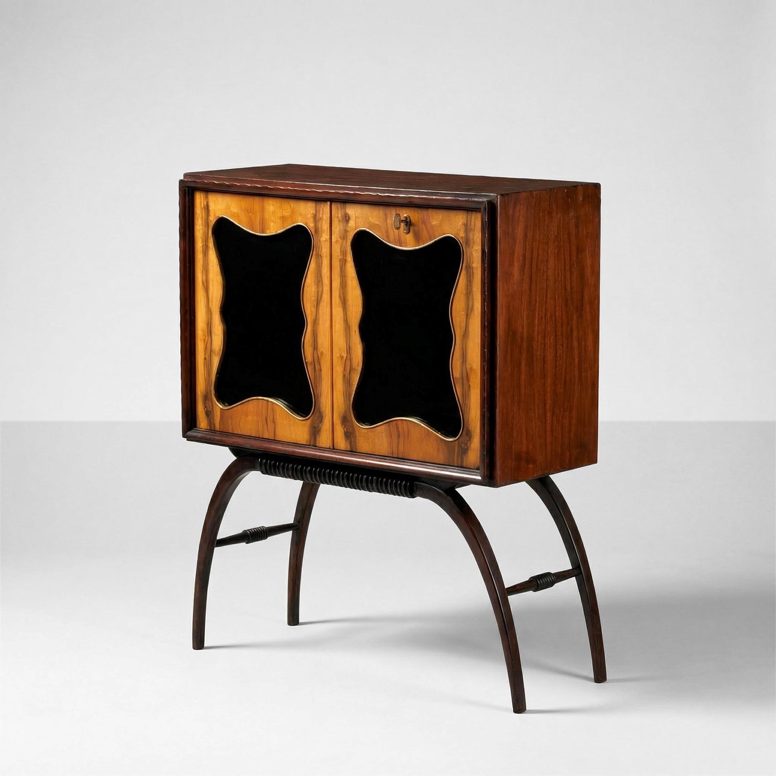 Mobile bar: Sostegni in legno grissinato e struttura in legno impiallacciato. Dettagli in ottone e ante rivestite di vetro colorato. Interni con rivestimenti in cristallo specchiato e mensole in cristallo molato.