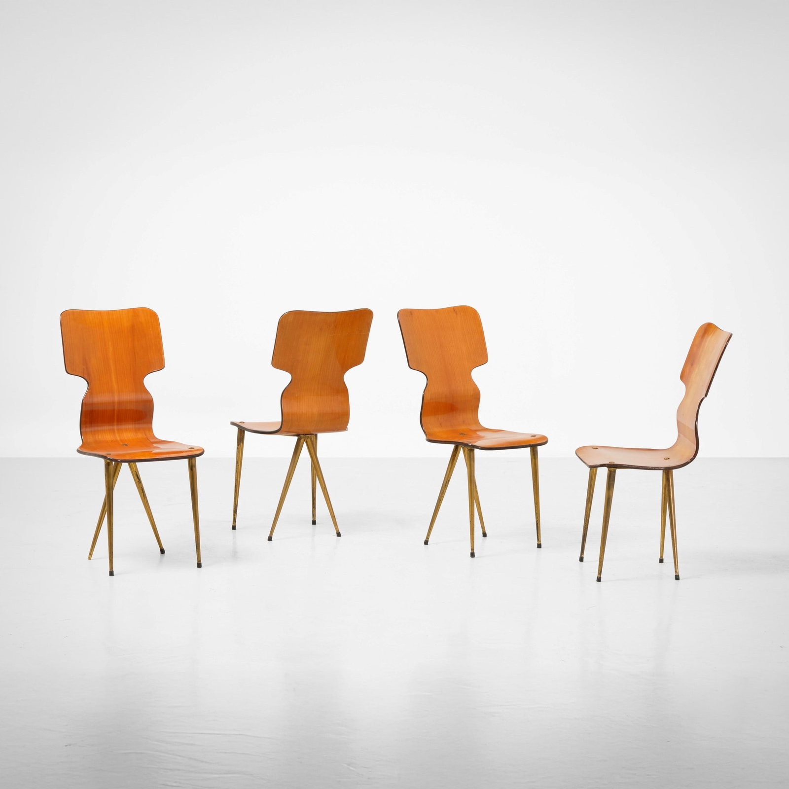 Quattro sedie: Struttura in legno compensato curvato e sostegni in ottone. Prod. Italia, 1950 ca.