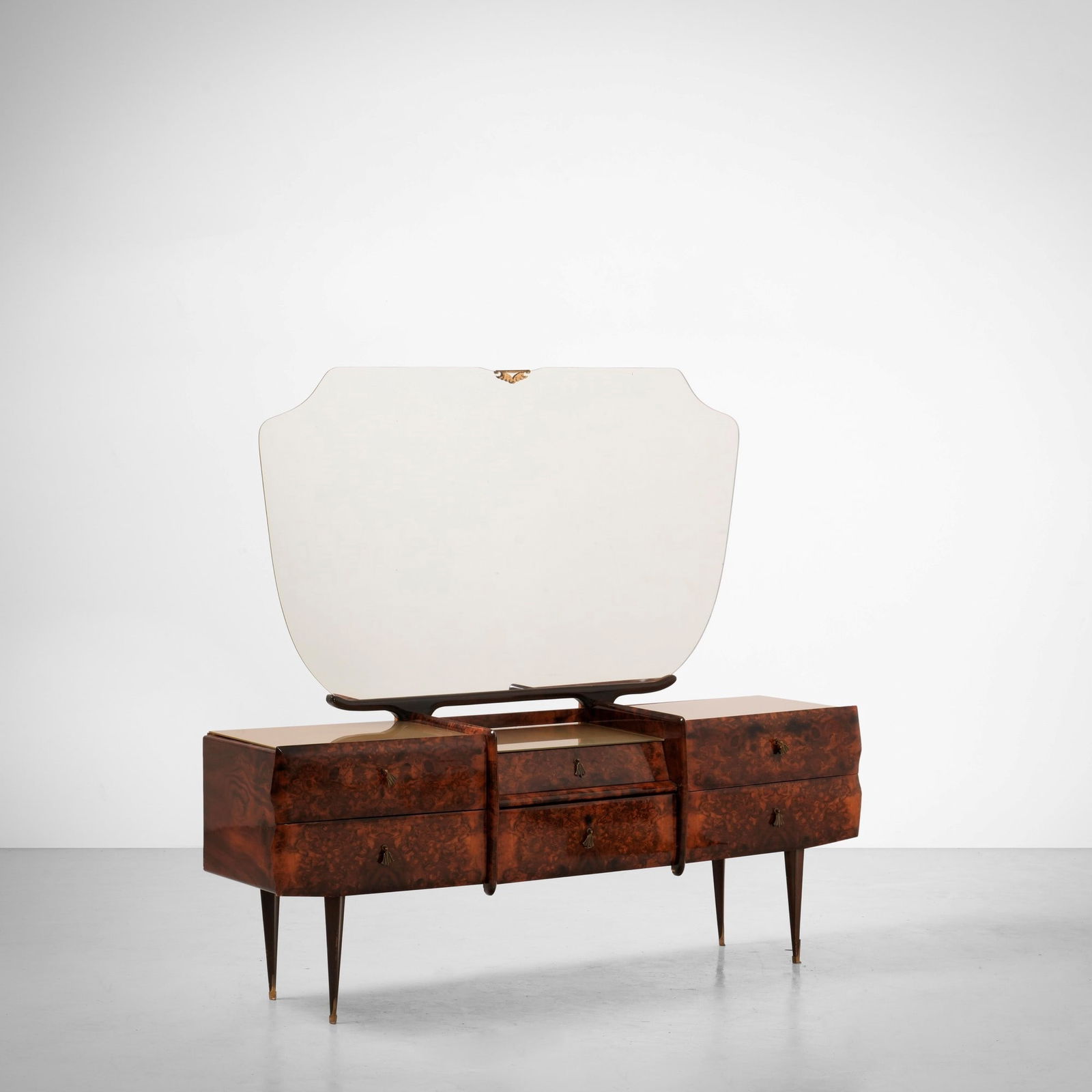 Coiffeuse: Struttura in legno e impiallacciatura di radica. Piano in vetro colorato e cristallo specchiato. Maniglie, puntali e dettagli in ottone. Prod. Italia, 1950 ca.