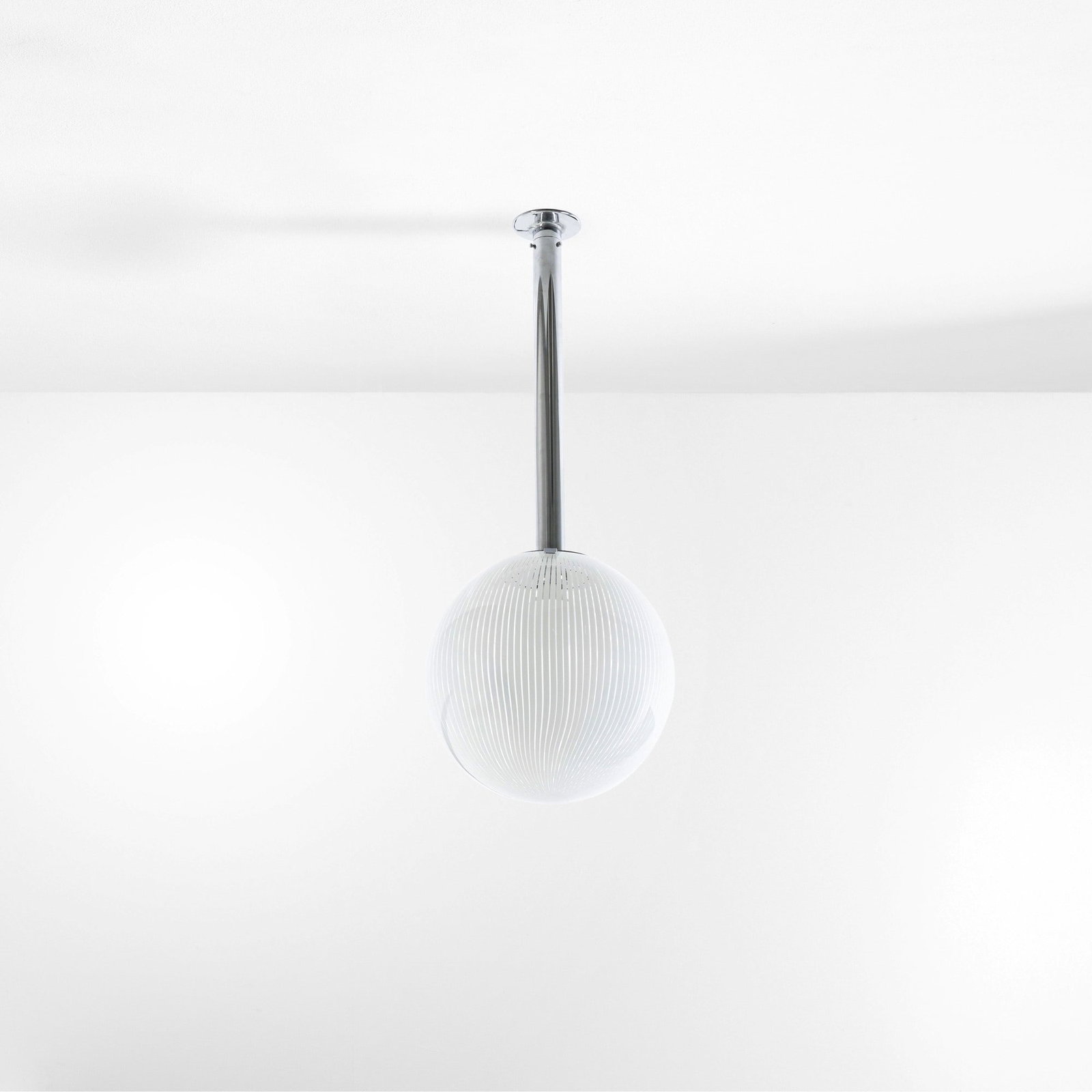 Venini Lampada a sospensione della serie Tessuto: Struttura in metallo cromato e diffusore in vetro di Murano trasparente con inclusione di canne in vetro lattimo. Marchio incusso. Prod. Venini, Italia, 1970 ca.