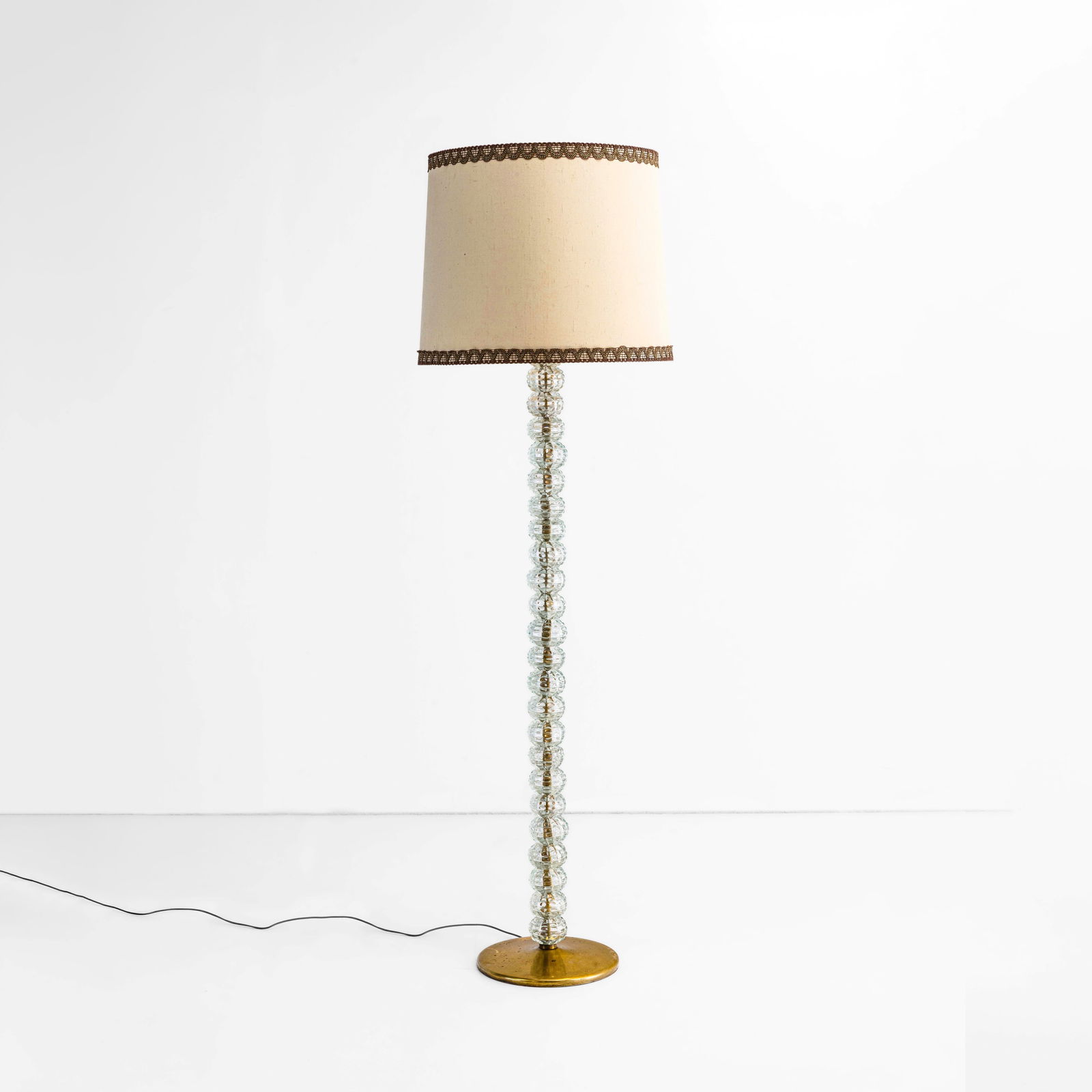 Carlo Scarpa Lampada da terra mod. 530: Struttura in ottone e vetro di Murano bugnato e rigato tondo. Paralume in tessuto. Marchio incusso. Prod. Venini, Italia, 1942. M. Barovier, C. Sonego, Venini Luce 1921-1985, Skira, p. 574, tav. 178