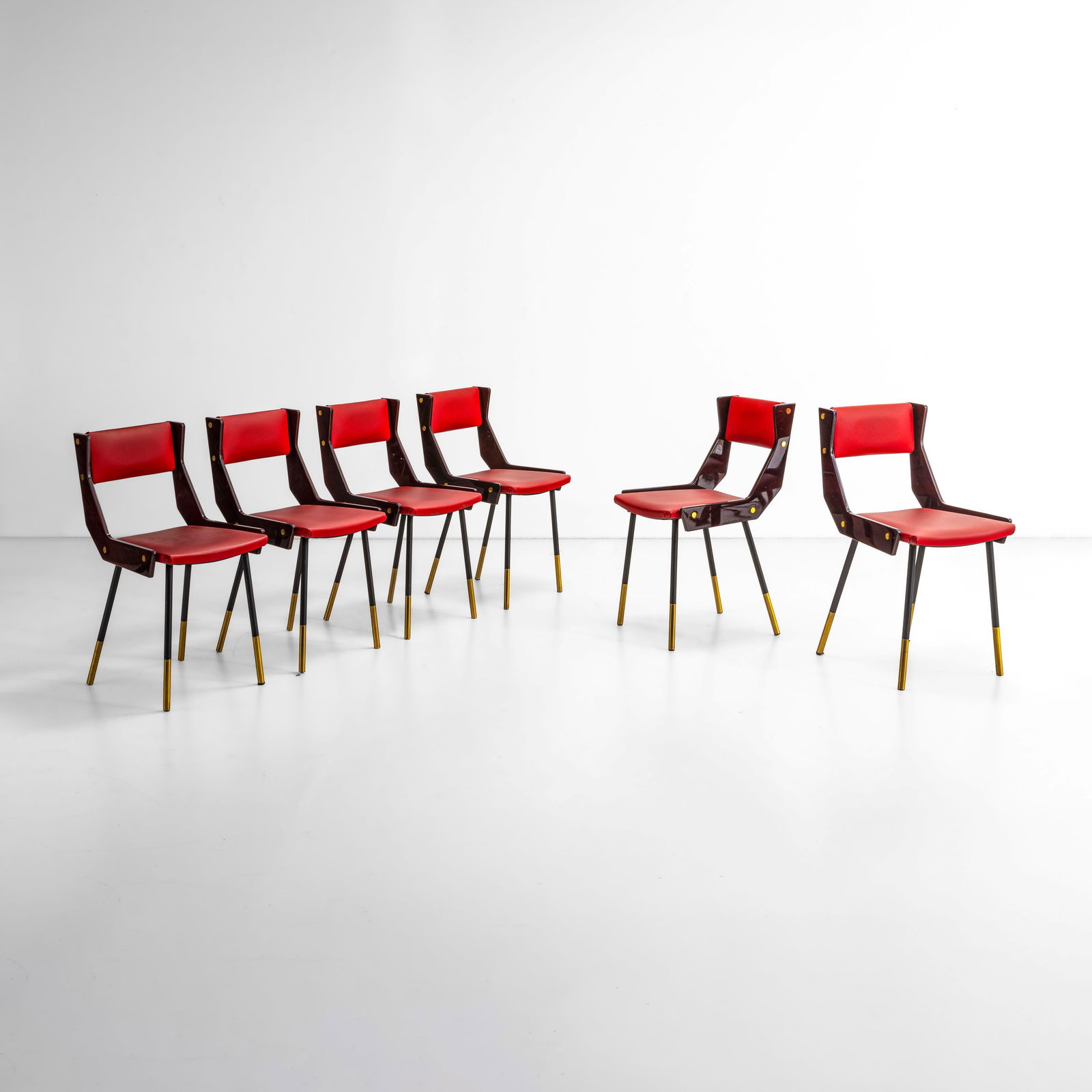 Gianfranco Frattini Sei sedie: Struttura in metallo tubolare e in legno laccato. Dettagli e in ottone e rivestimenti in skai. Prod. Italia, 1950 ca.
