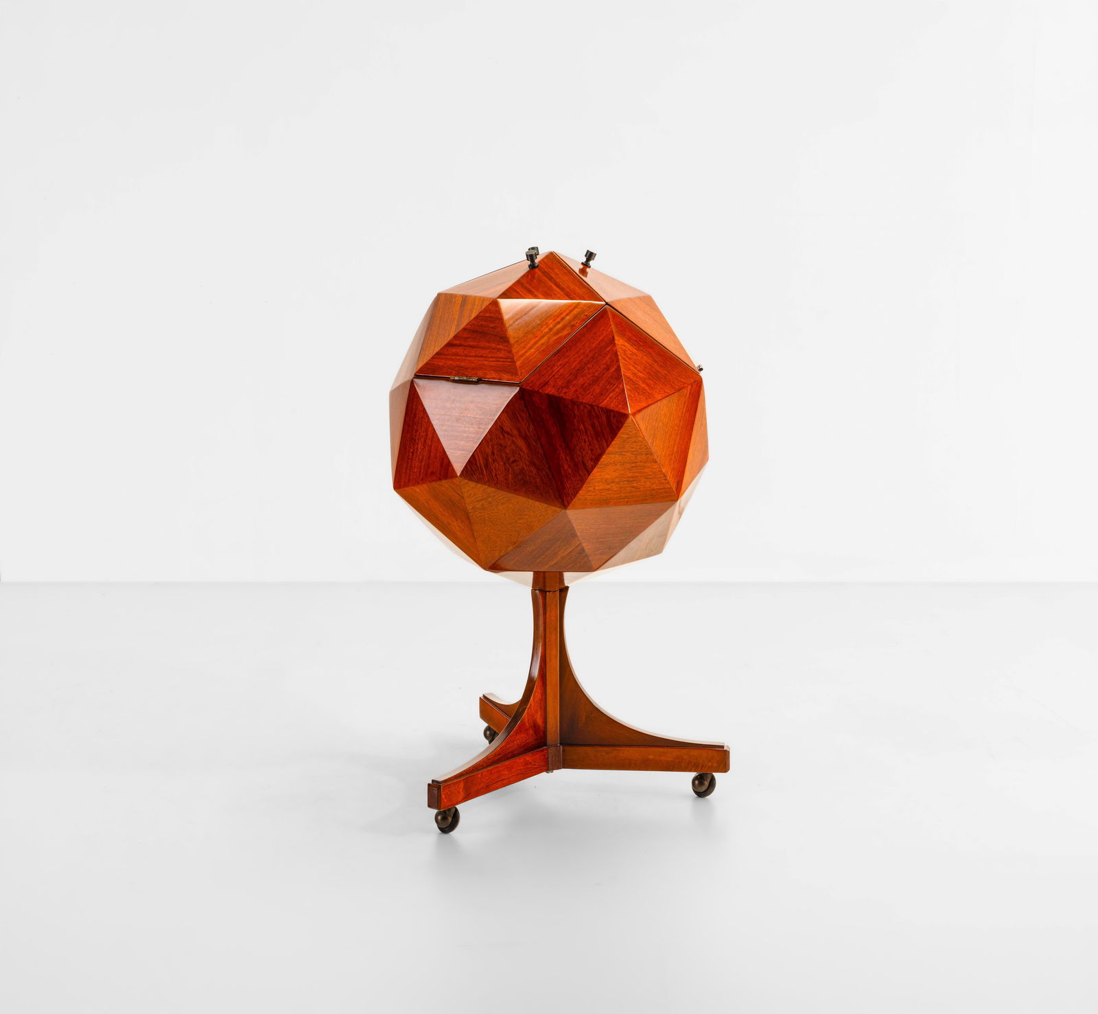 Vuillermoz Mobile bar poligonale: Struttura in legno, ante a ribalta con vano portabottiglie. Dettagli in ottone e ruote in metallo e materiale plastico. Prod. Francia, 1960 ca.