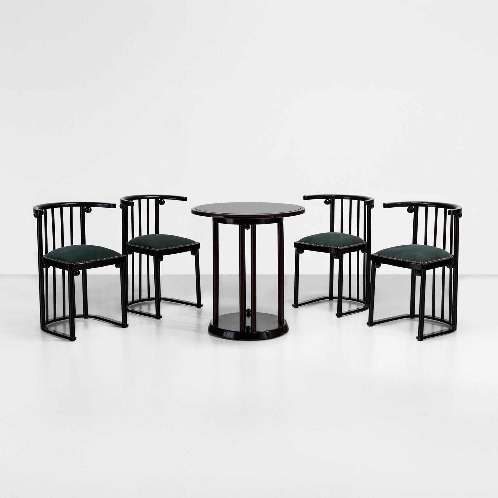 Josef Hoffmann Tavolo e quattro sedie: Struttura in legno laccato. Rivestimento in tessuto e dettagli in metallo. Prod. Vienna, 1900 ca. cm 66x h74 (tavolo) 53x43x h74 (sedie) . Misure: