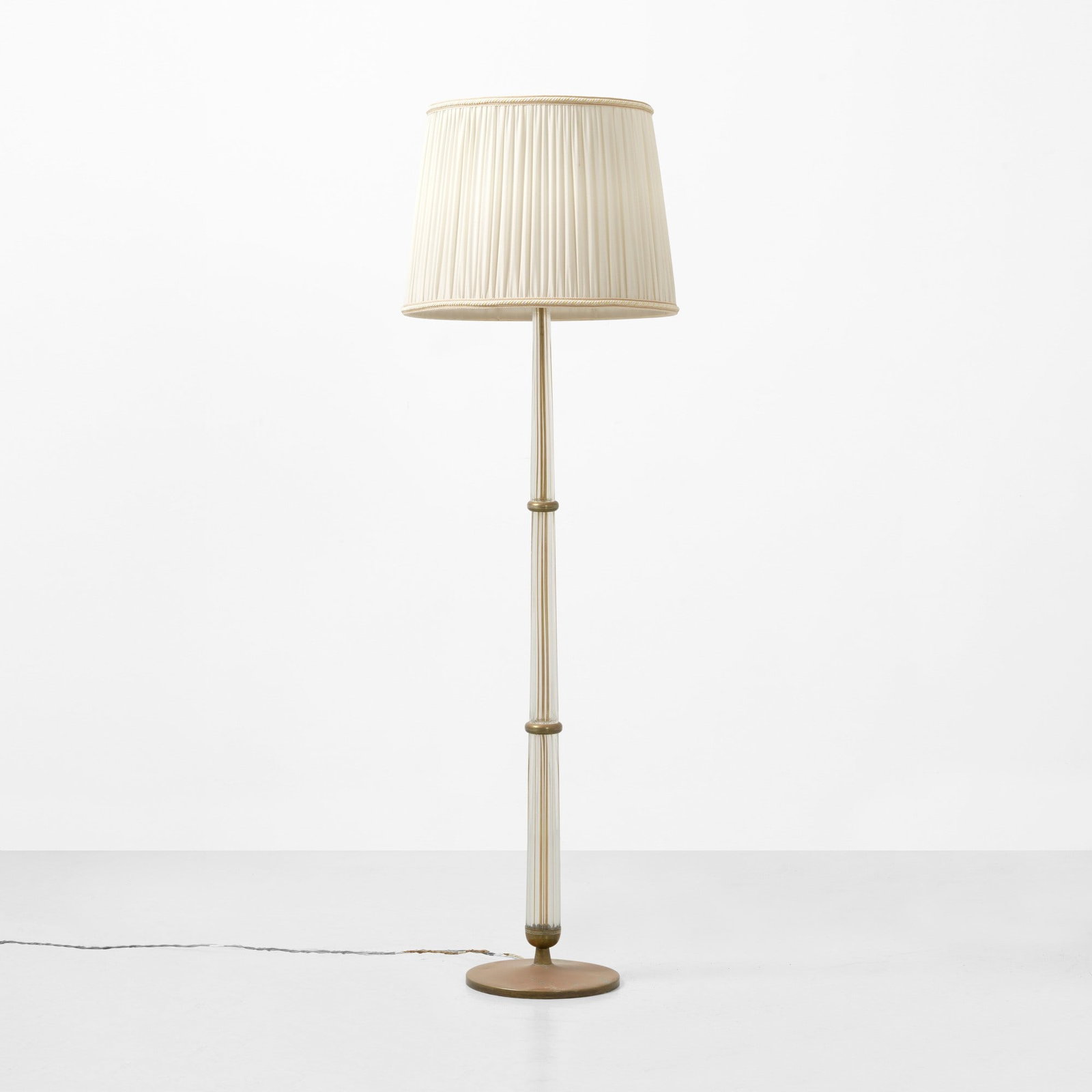 Tomaso Buzzi Lampada da terra mod. 502: Fusto tripartito in vetro di Murano. Raccordi e struttura in ottone. Paralume in tessuto. Marchio originale incusso. Prod. Venini, Italia, 1933. Domus n. 125, maggio 1938, p. 67 F. Deboni, Venini I