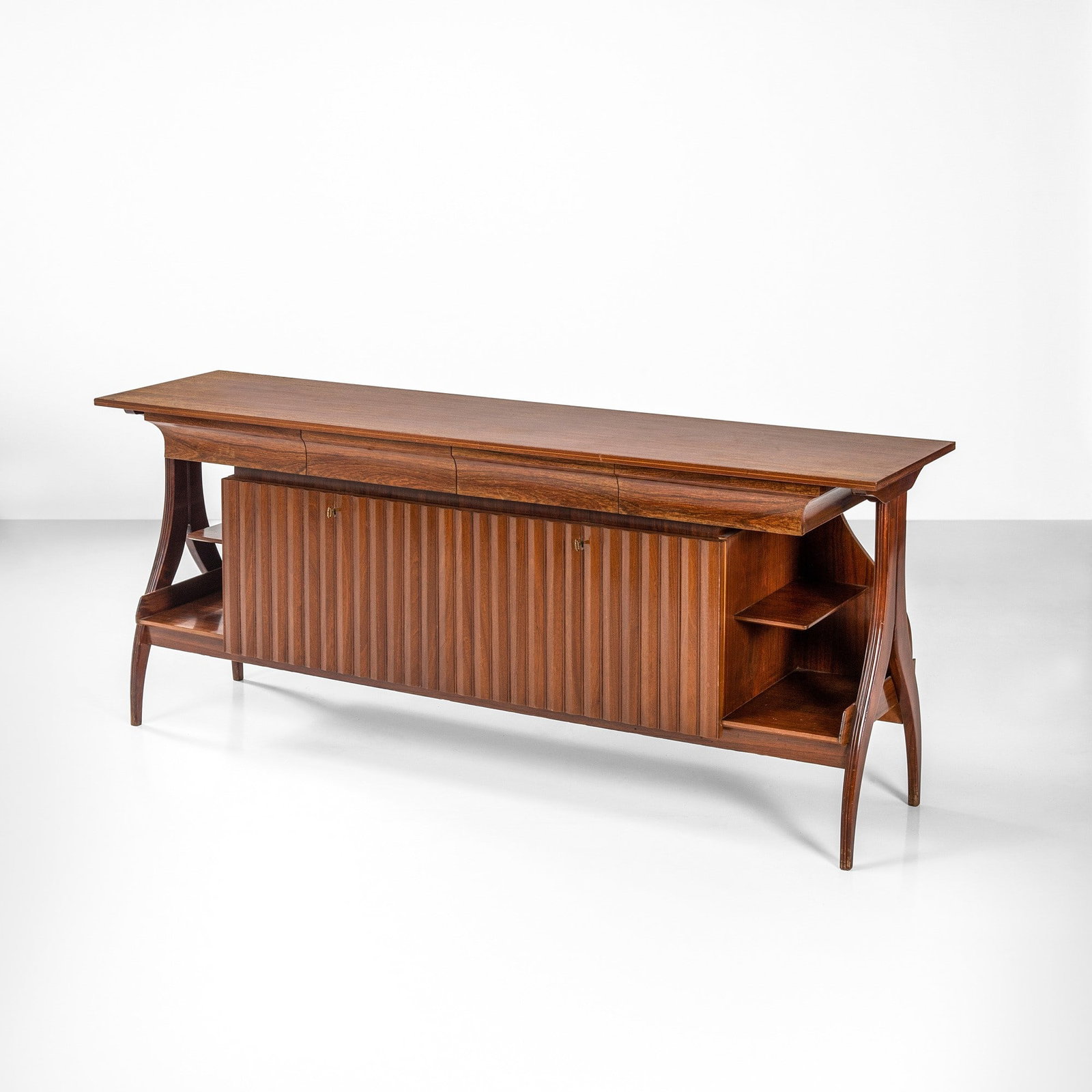 Paolo Buffa Mobile contenitore: Struttura in legno impiallacciato e grissinato. Dettagli in ottone. Prod. Italia, 1950 ca. . Measuers: W. 217 - D. 40 - H. 90 cm