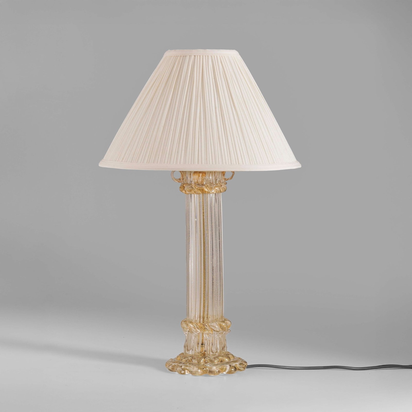 Fulvio Bianconi Lampada da tavolo mod. 9054 della serie Colonna: Struttura in ottone e vetro di Murano e inclusioni in oro. Paralume in tessuto. Firma originale. Prod. Venini, Italia, 1950 ca. . Measuers: W. 36 - H. 63 cm