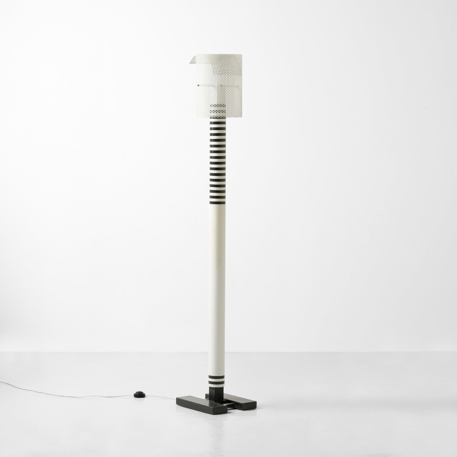 Mario Botta Lampada da terra mod. Shogun: Struttura in metallo laccato e diffusore in alluminio laccato traforato. Prod. Artemide, Italia, 1986. G. Gramigna, Repertorio del design italiano 1950-2000, p. 368, Allemandi, 2021 . Measuers: cm 34X