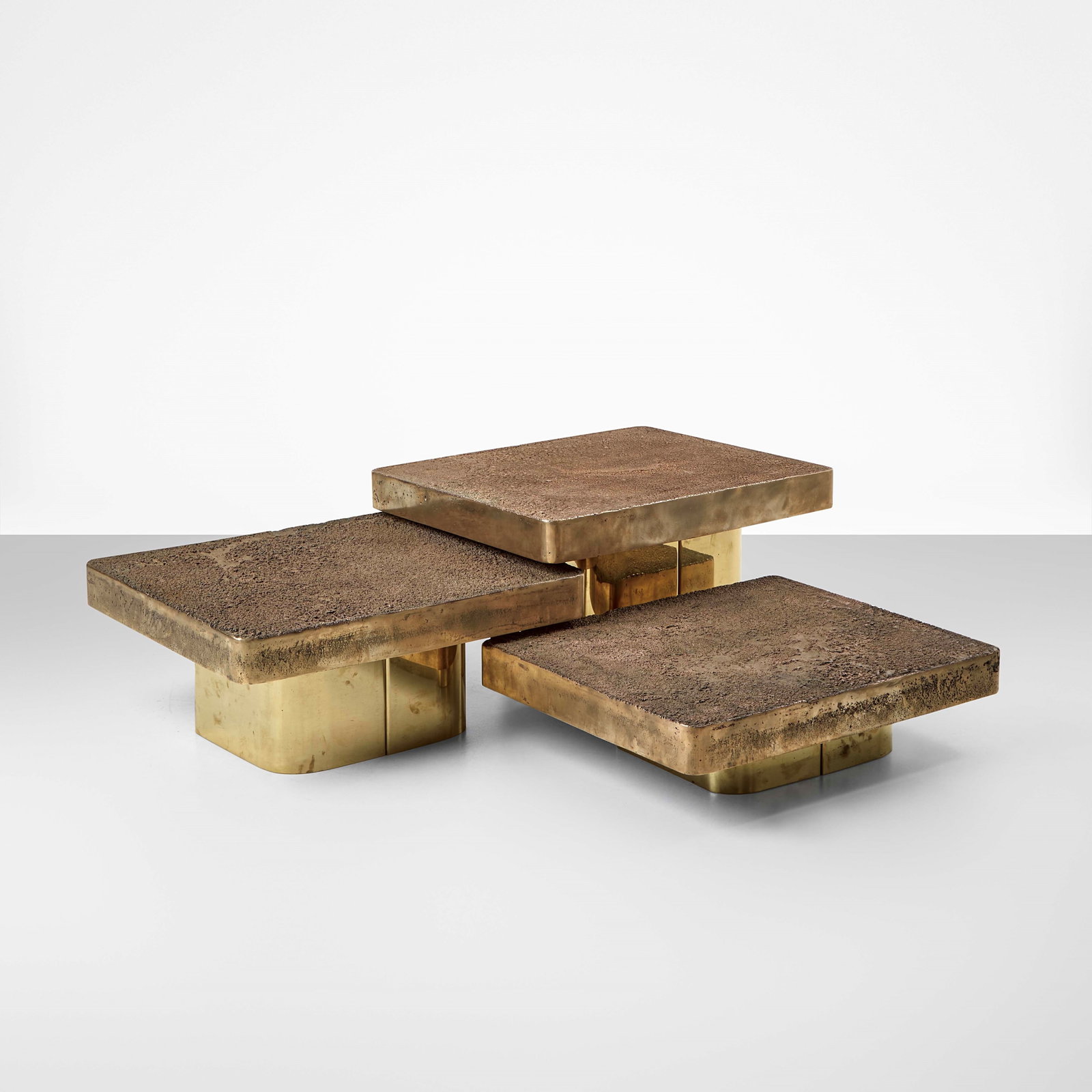 Georges Mathias Set of three low tables: Structure in brass and bronze. Engraved signature. Belgium, 1975. . Measuers: W. 134 - D. 121 - H. 39 cm