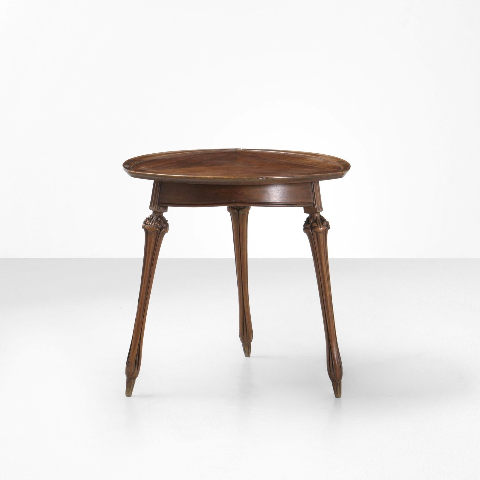 Louis Majorelle Tavolo occasionale: Struttura e piano in legno impiallacciato e scolpito. Prod. Francia 1900 ca. . Measuers: Cm 77X77X76