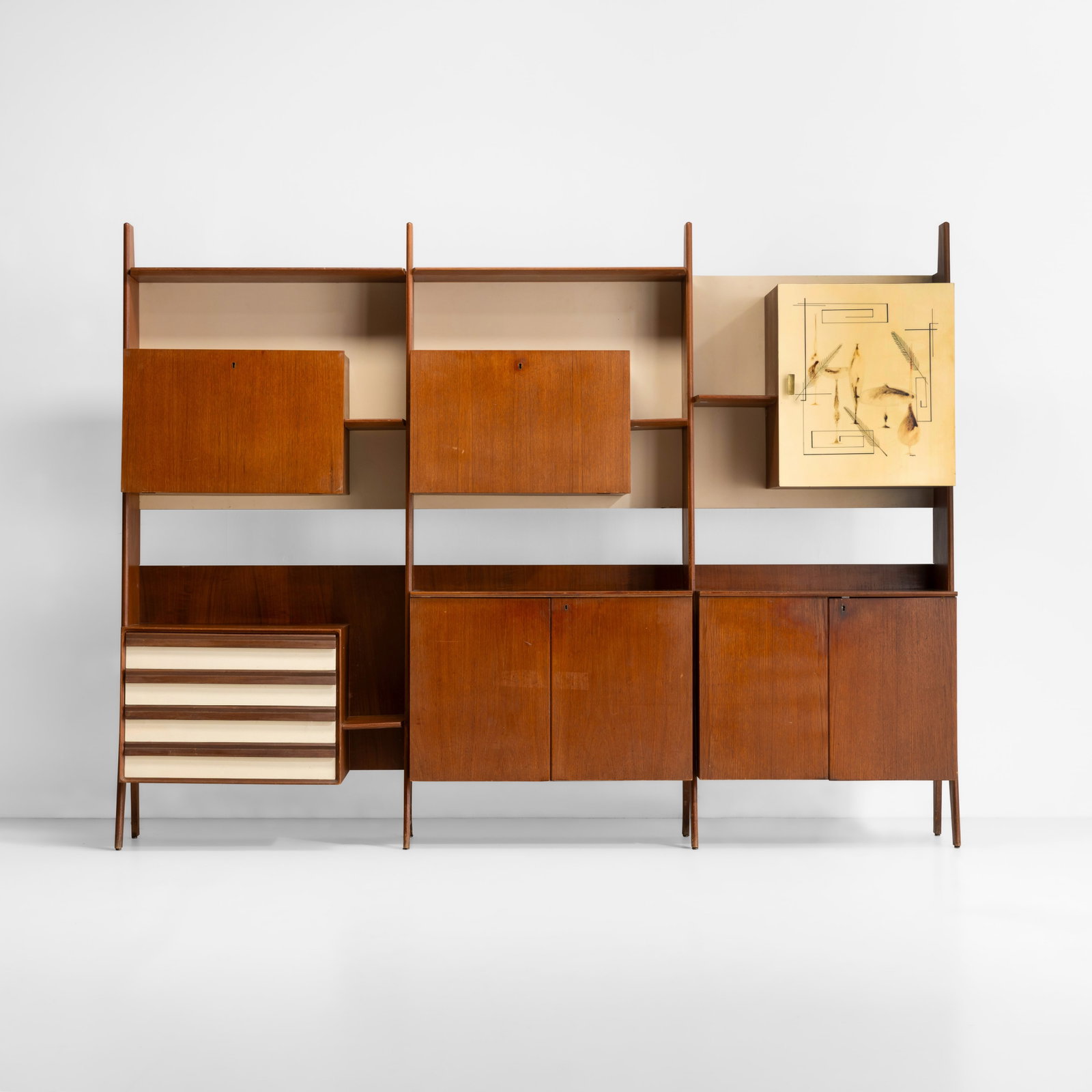 Vittorio Dassi Libreria con moduli contenitori: Struttura in legno legno impiallacciato e dettagli in metallo. Anta in legno laccato a decoro firmato P. Toppi. Maniglia e dettagli in ottone. Prod. Dassi Italia 1950 ca. . Measuers: Cm 247X42X186