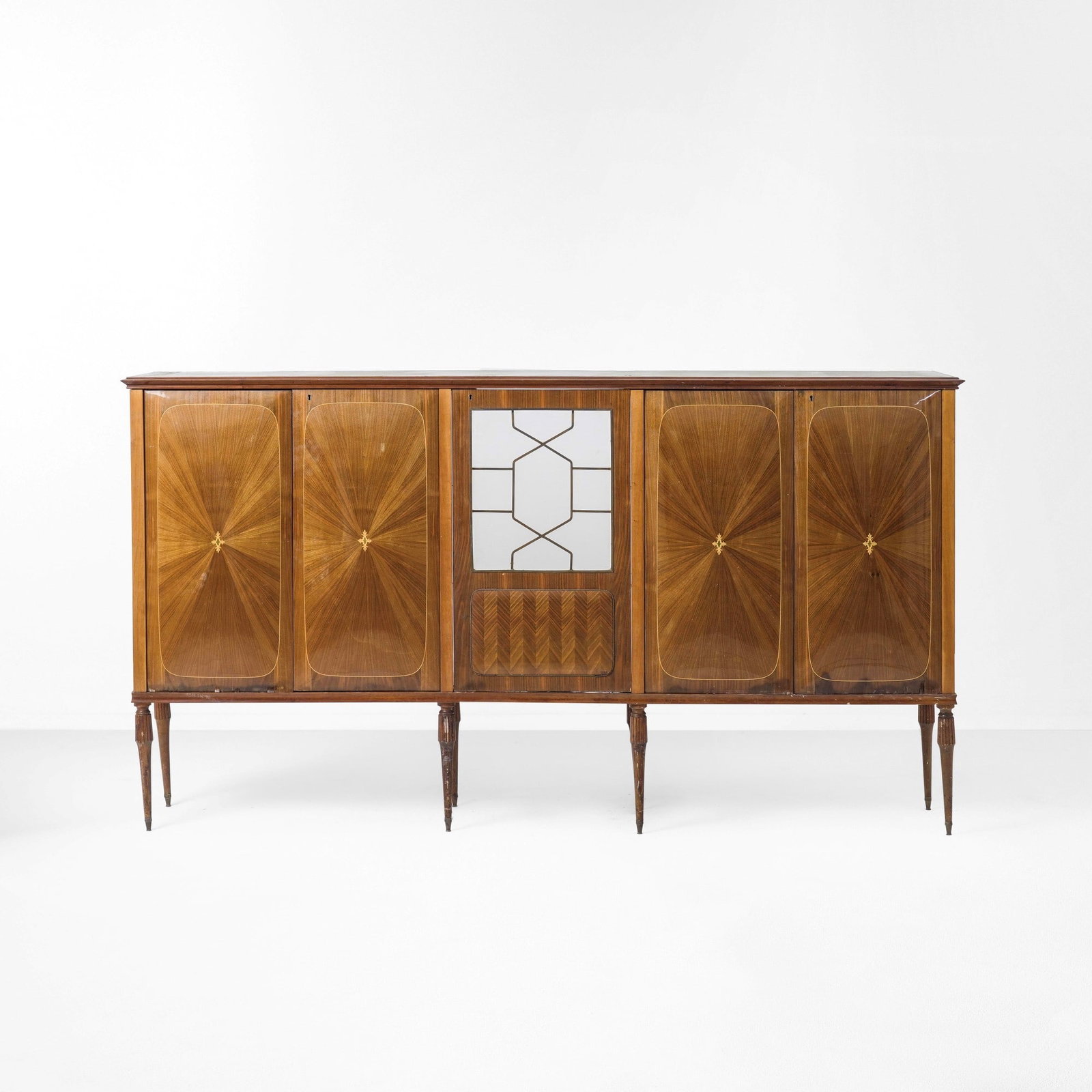 Mobile contenitore: Struttura in legno e legno impiallacciato e filettato. Piano in vetro. Anta centrale rivestita di cristallo specchiato con elementi in ottone. Prod. Italia 1950 ca. . Measuers: cm 260X48X140