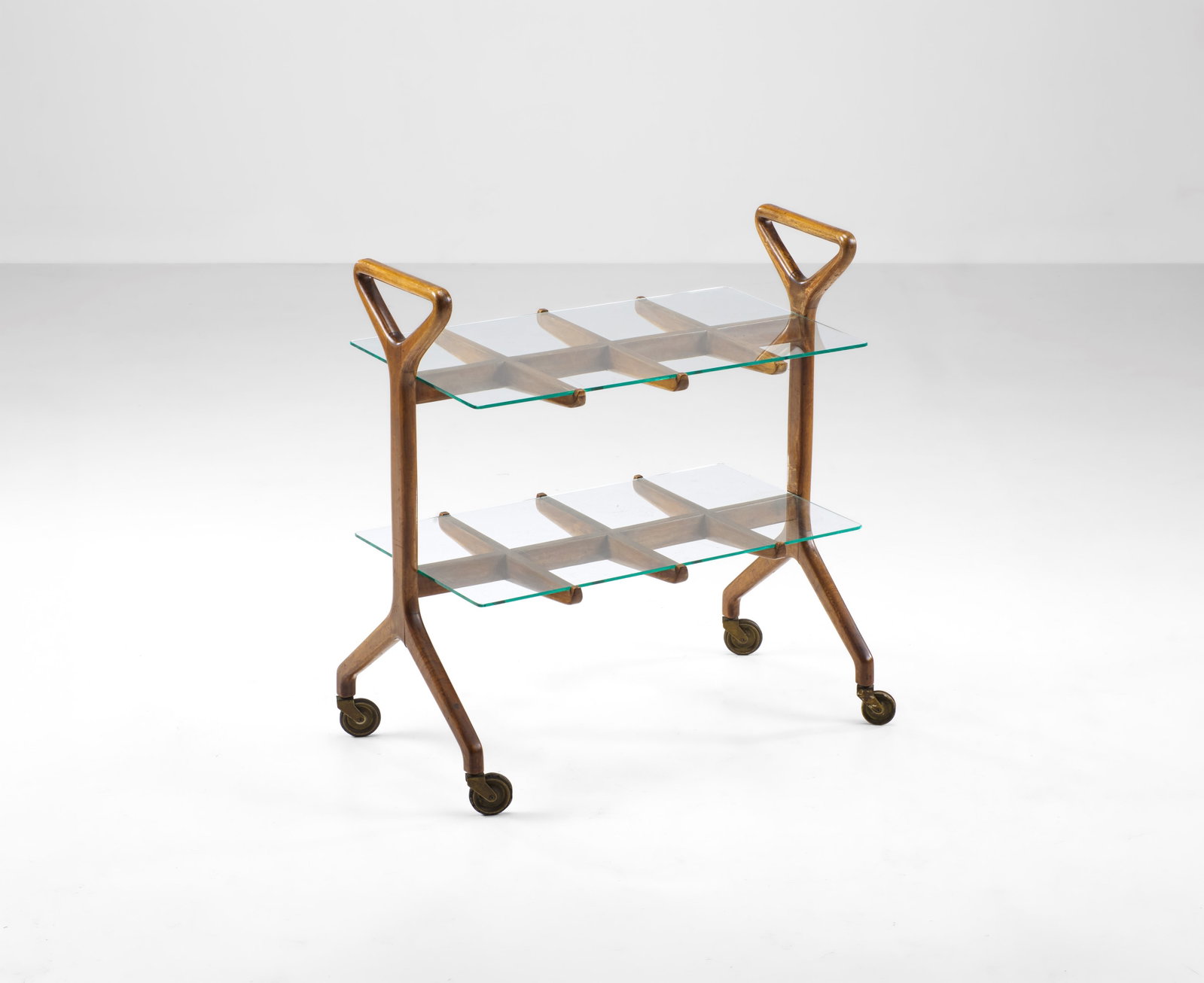 Tavolo da servizio.: Struttura in legno, piani in vetro. Ruote in metallo e gomma. Prod. Italia, 1950 ca. . Measuers: W. 69 - D. 40 - H. 75 cm