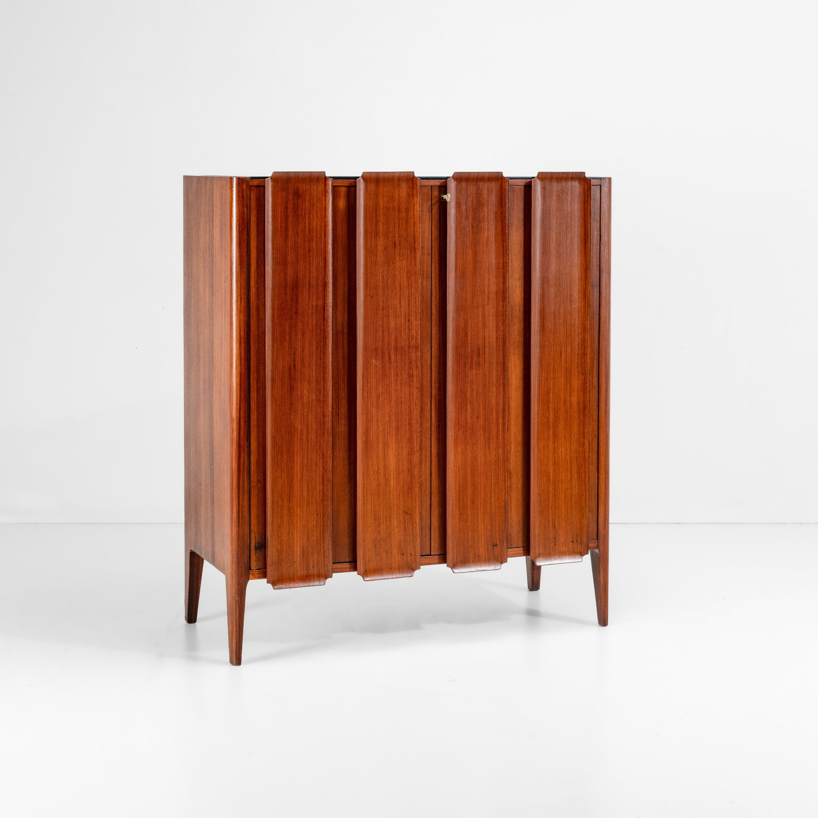 Paolo Buffa Un mobile contenitore: Struttura in legno con elementi frontali in legno lavorato. Vetro colorato. Prod. Italia, 1950 ca. . Measuers: cm 110X51X126