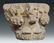 A stone capital carved on two sides with