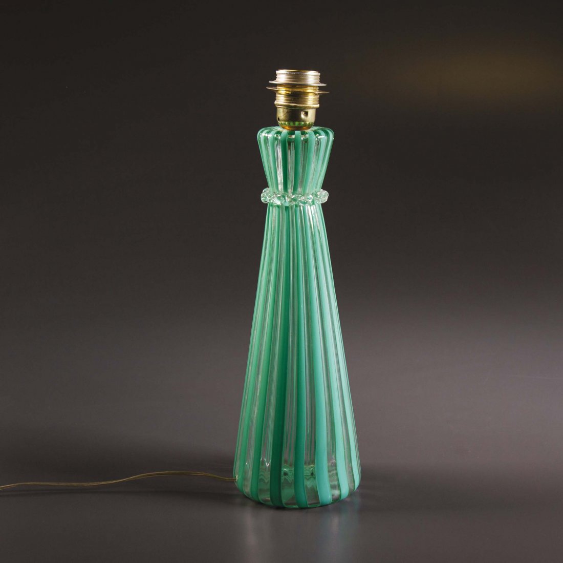 Gio Ponti,: Lampada da tavolo in vetro di Murano soffiato a canne e ottone. Timbrata all’acido. Prod. Venini, Italia, 1950 ca. cm 13x42