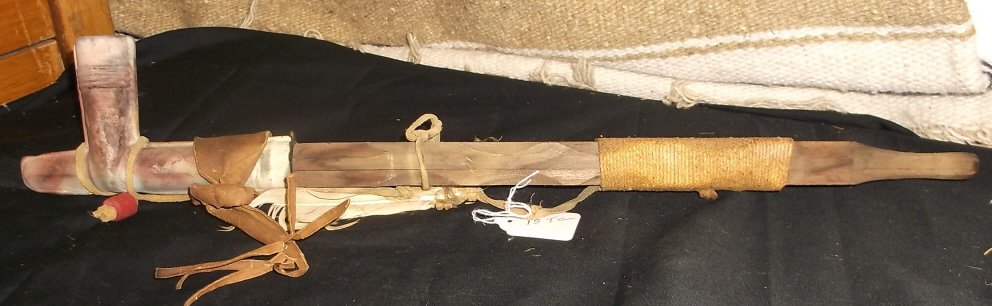 Native American Peace Pipe - Clay Bowl: - Wood - String - Leather - Feather 20” long, all natural materials, may have been used. Promote piece with it, hang it on the wall or have a smoke! All sizes approximate