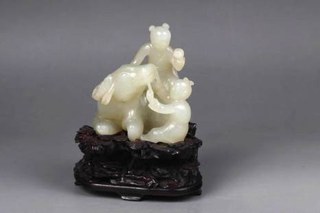 AN CHINESE QING DYNASTY CARVED WHITE JADE,: AN CHINESE QING DYNASTY CARVED WHITE JADE,Jade carved two kids playing with a cow, one kid using a string to control the cow and one sitting on it. A wooden stand is included. 8cm X 5cm