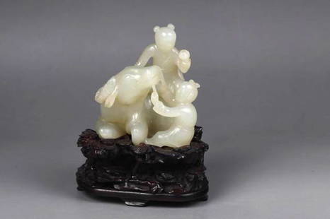 AN CHINESE QING DYNASTY CARVED WHITE JADE，: AN CHINESE QING DYNASTY CARVED WHITE JADE，Jade carved two kids playing with a cow, one kid using a string to control the cow and one sitting on it. A wooden stand is included. 8cm X 5cm