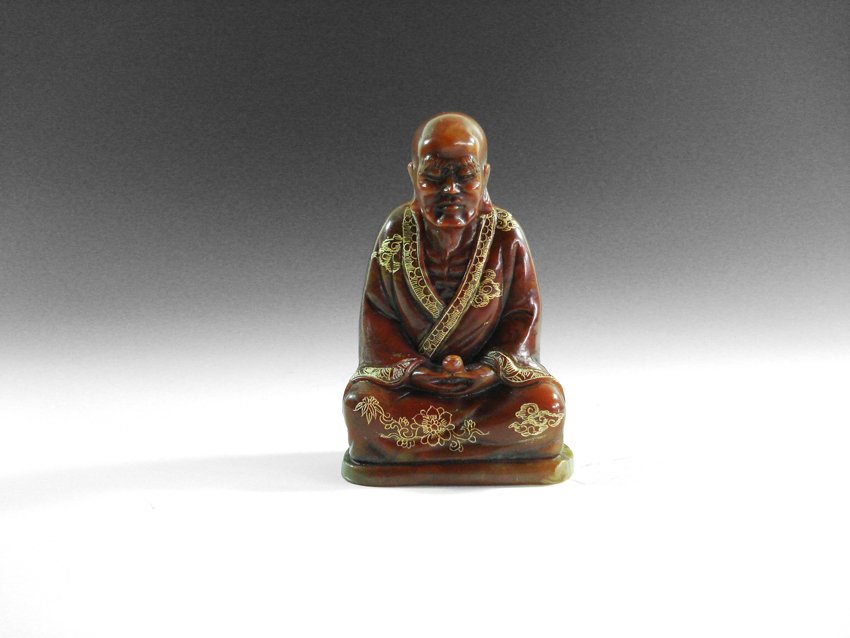 A CHINESE SHOUSHAN STONE BUDDHA FIGURE: A CHINESE SHOUSHAN STONE BUDDHA FIGURE A little buddha figure showing a skinny old man sitting down with eyes closed, his shirt is painted with gold flowers. H 4.5" X W 3"