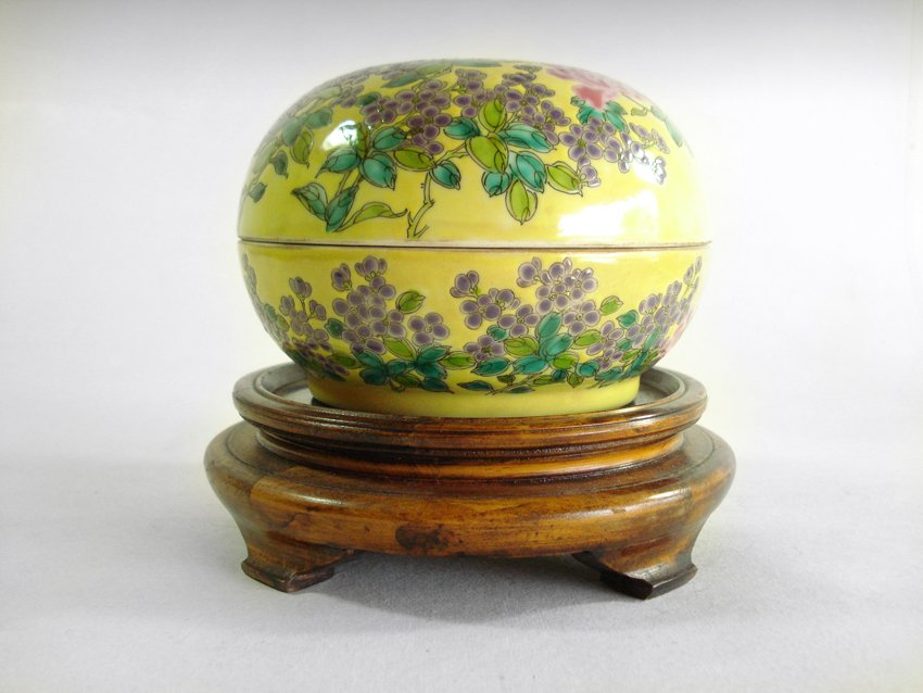 AN CHINESE QING DYNASTY FLOWERS AND PLANTS PORCELAIN BO: AN CHINESE QING DYNASTY FLOWERS AND PLANTS PORCELAIN BOX, This yellow earth shaped container had some painted grapes for decordation and the background color is yellow; the stand has three short legs;