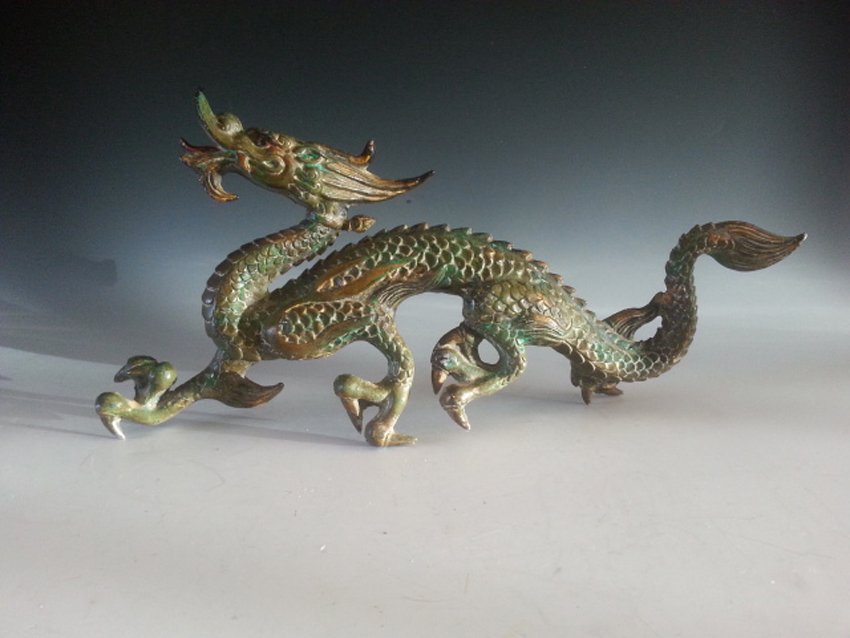 A BRONZE RUNNING DRAGON: This bronze statue showing a dragon wth long strong legs runnng. It has a sort of long tail and the dragon seem happy according to it's face.