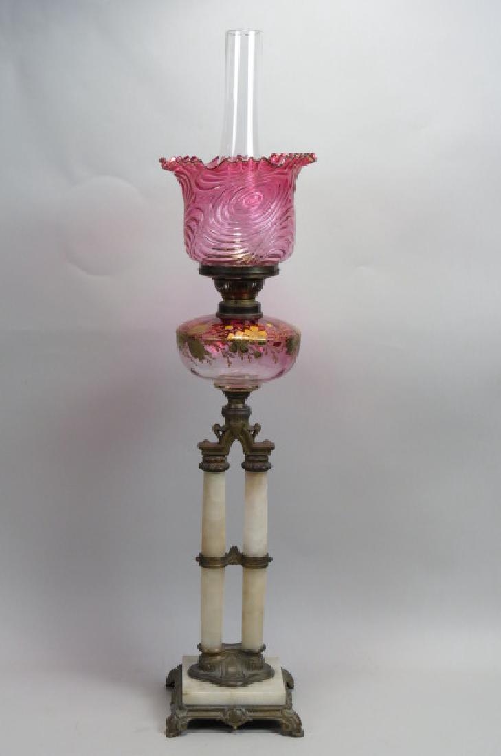 Victorian Cranberry Glass & Alabaster Banquet Lamp: Victorian Cranberry Glass & Alabaster Banquet Lamp , double columns supporting an enameled and gold decorated cranberry font, swirling cranberry shade above, bronzed trim, 30" tall.