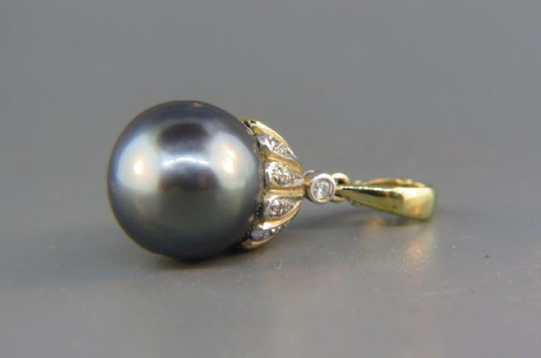 Black Tahitian Pearl & Diamond Pendant,: 13.5 mm pearl with 9 round diamonds totaling .23 carat in 14K yellow gold, with appraisal of $1,200.00, 1 1/8" long.