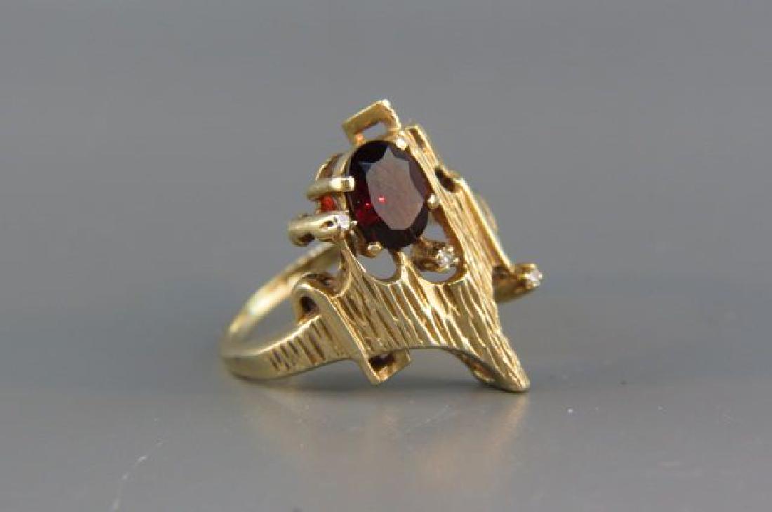 Garnet & Diamond Ring,: rich oval gem weighing 1 carat and 3 small diamonds in Modernist style 14K yellow gold, currently size 8 1/2.