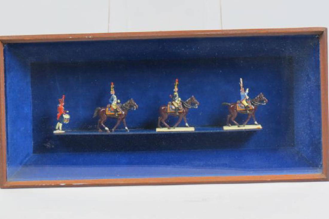 4 Lead Military Figurines,: 3 are on horseback (3" tall) followed by a drummer, in shadowbox frame measuring 8" X 17".