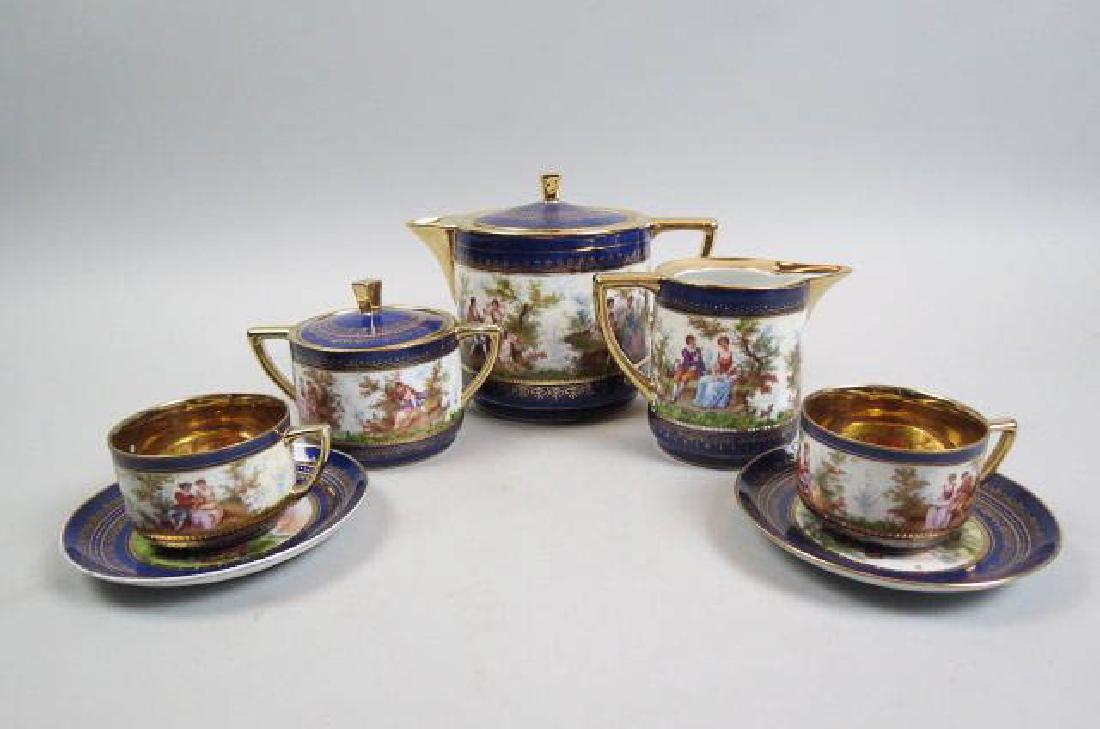 Fine Porcelain Tea for Two Service,: romantic scenes of couples in the garden, cobalt and gold trim, includes teapot, creamer, sugar, two cups and two saucers.