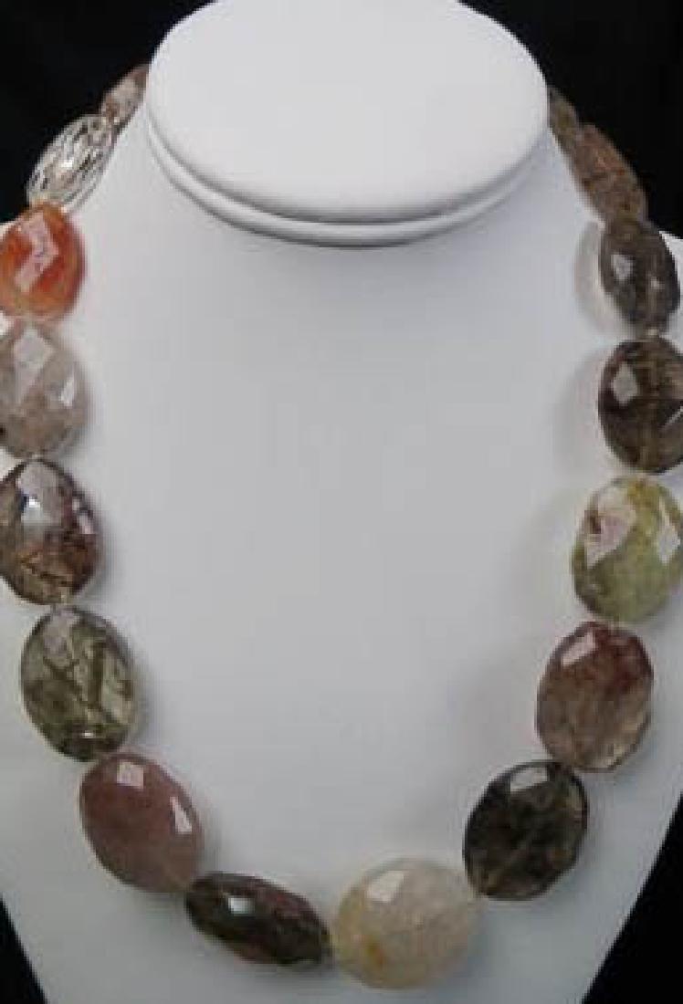 Rutilated Quartz Necklace,: 18 fancy cut flat oval beads in various colors, up to 22" long, sterling clasp.