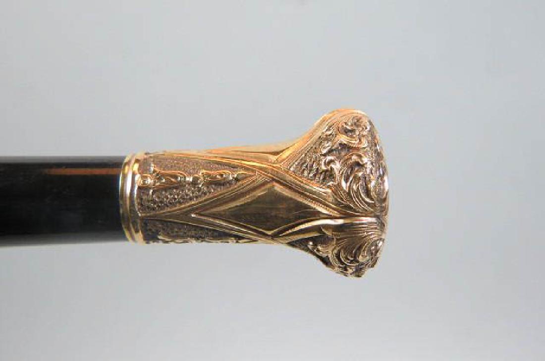 Victorian Gold-Filled Handled Cane,: elaborate engraving with floral, marked "J.M. Iseminger from Employees" and "89" for 1889, ebony stick, overall 33 1/2" long.