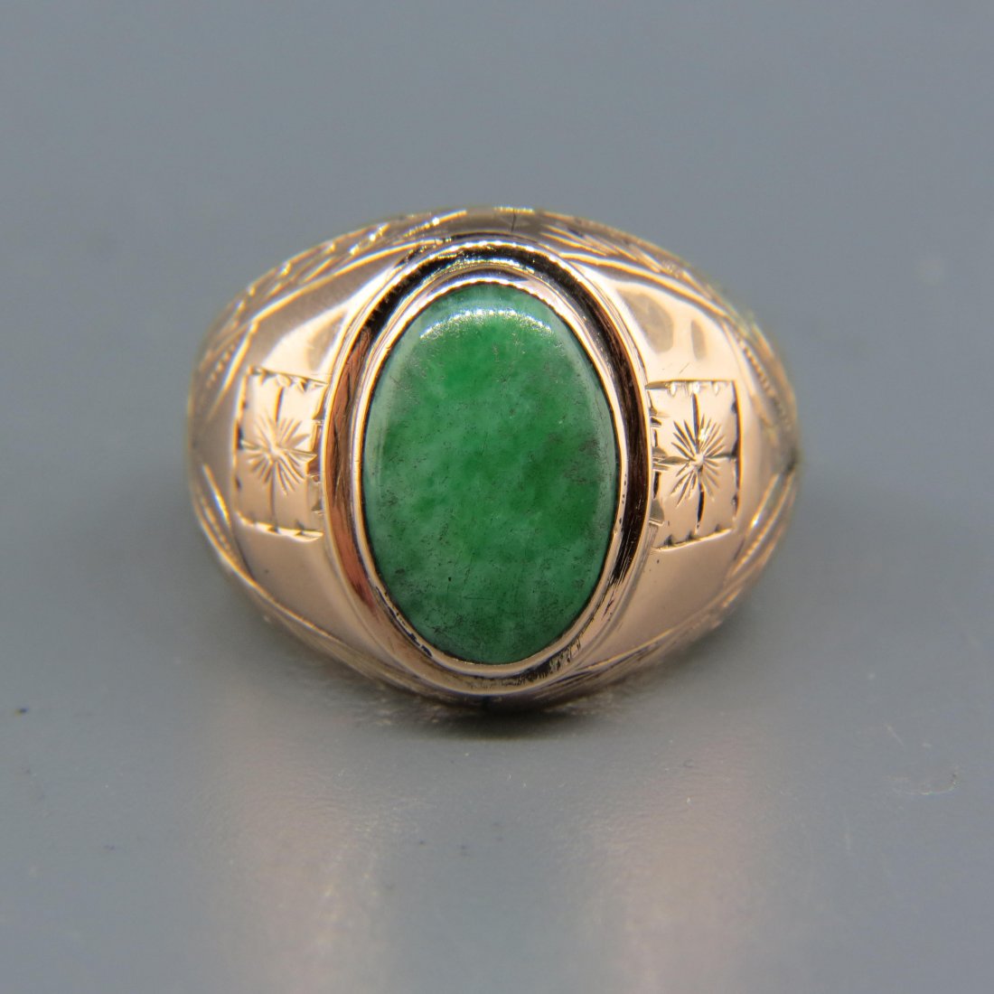 Chinese Jadeite 14K Gold Man: circa 1920's in rose color gold with fine engraving, the green jade measures approx. 10 X 15.5 mm, the gold setting weighing 10 grams. Size 10 1/4.