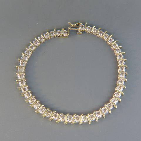 Diamond Bracelet,: straight line with 44 round diamonds totaling 5 carats in 14K yellow gold, with appraisal of $4,550.00, 7 1/4" long.