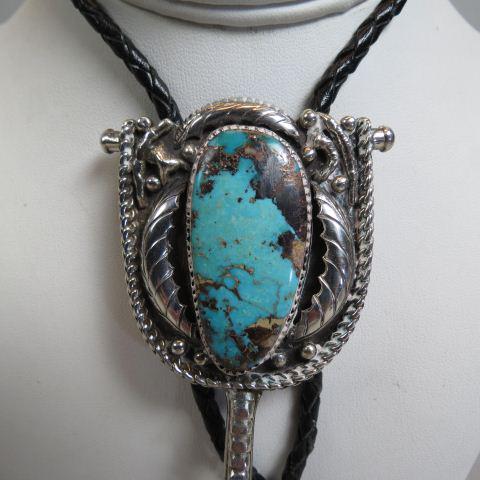 Navajo Turquoise & Sterling Bolo Tie,: rich elongated teardrop style stone in fancy setting, overall 2" X 2" plus a 1 1/4" spur decoration, woven black leather cord.