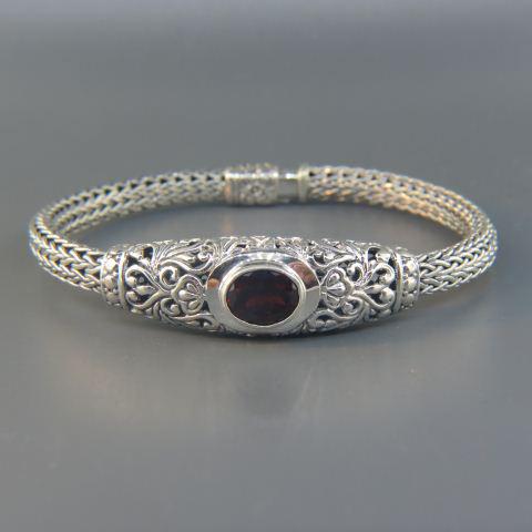 Garnet & Sterling Silver Bracelet,: vivid red oval gem weighing 5 carats in fancy openwork setting and cable band, 7 1/2" long, 28 grams.