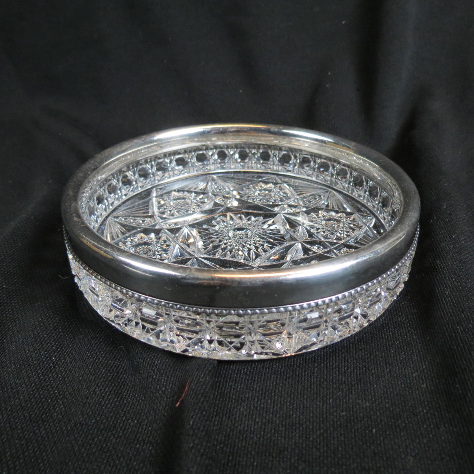 Brilliant Period Cut Glass & Sterling Wine Coaster: having a sterling rim, heavily cut with beaded silverwork by Gorham, 6" diameter.
