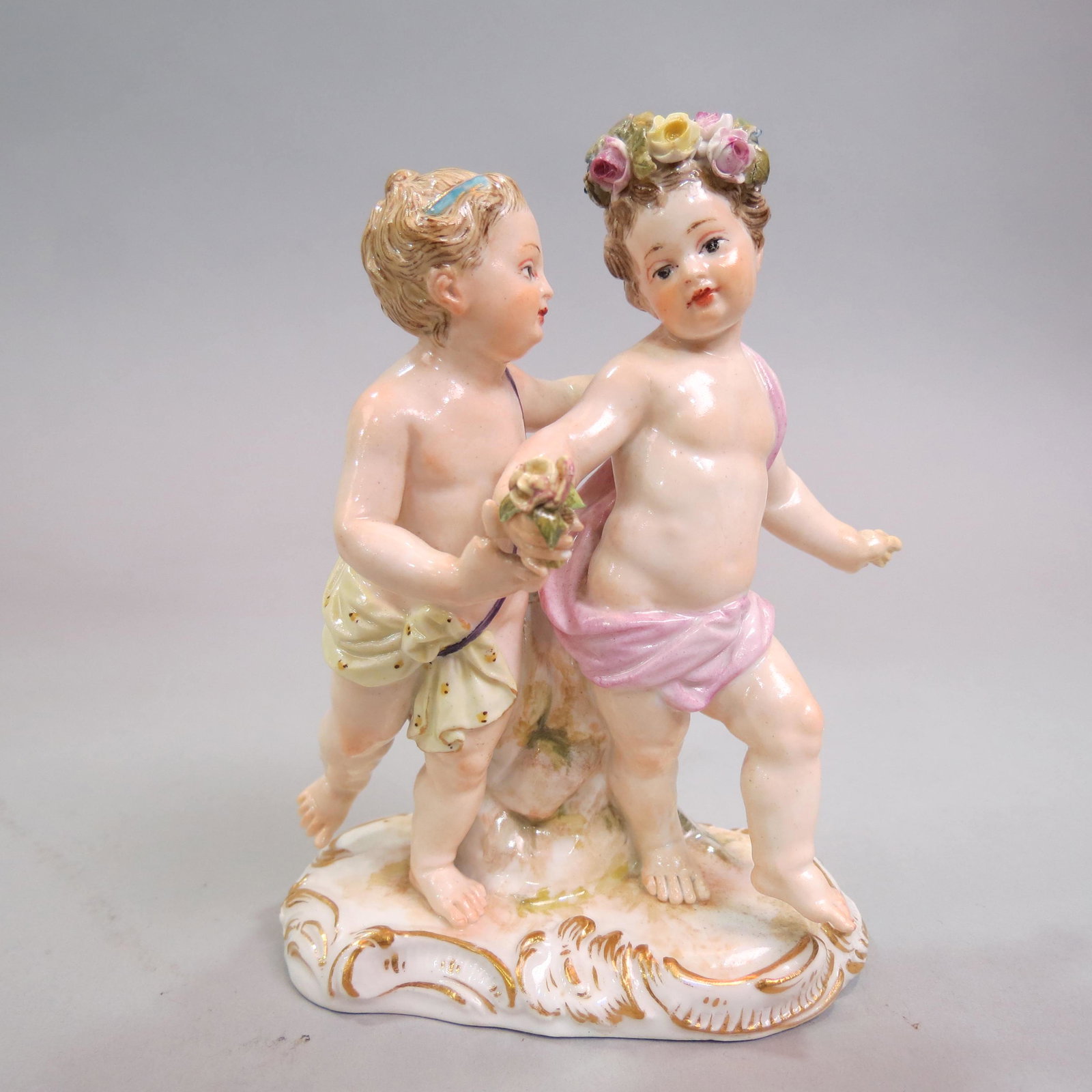 Meissen Porcelain Figurine of Children at Play,: or Putti, floral wreath in one's hair, #2990, 4 1/2", crossed swords mark.