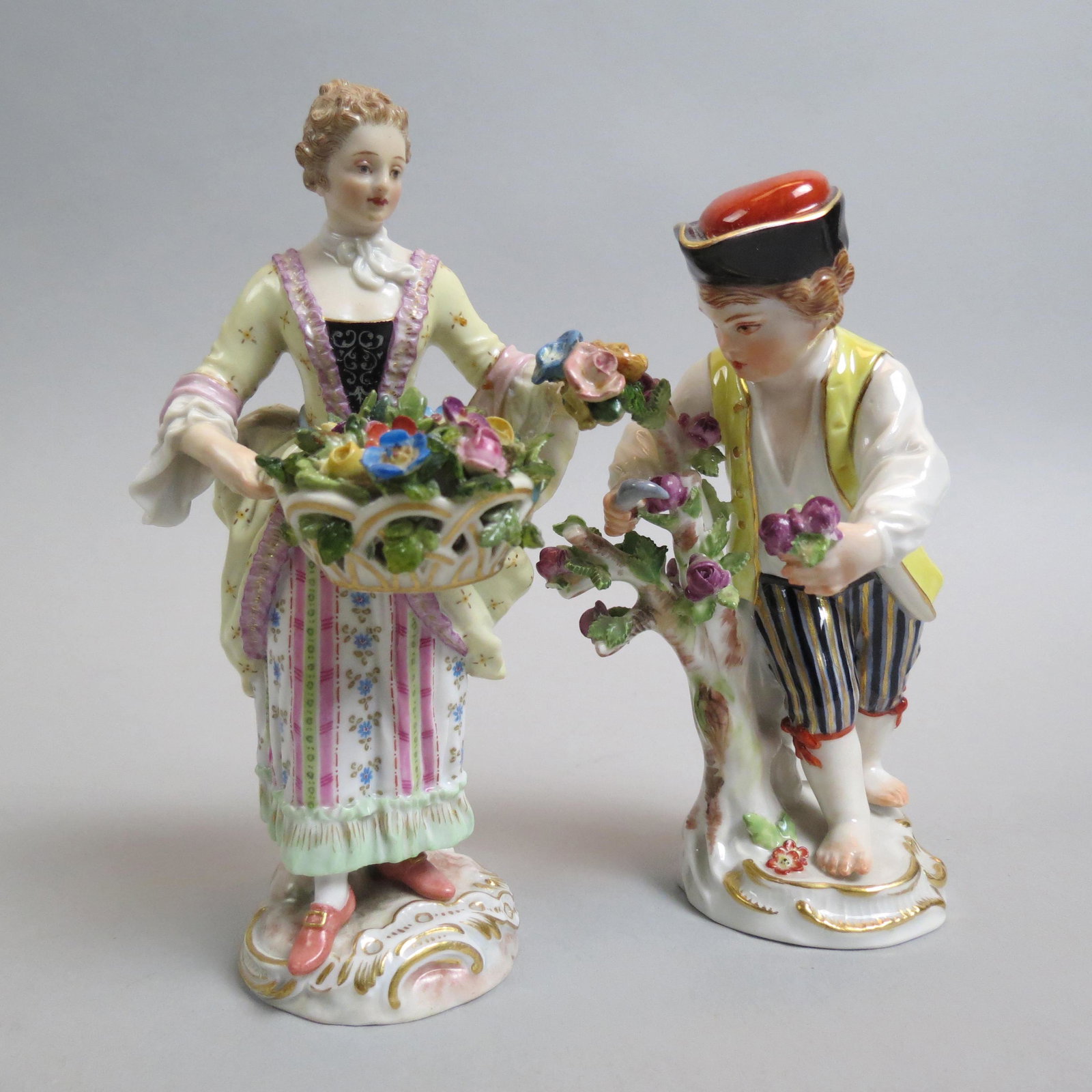 Pair of Meissen Porcelain Flower Seller Figurines,: her with a basket full, him harvesting flowers, 5", #777-25 and #28, some professional restoration, crossed swords marks.