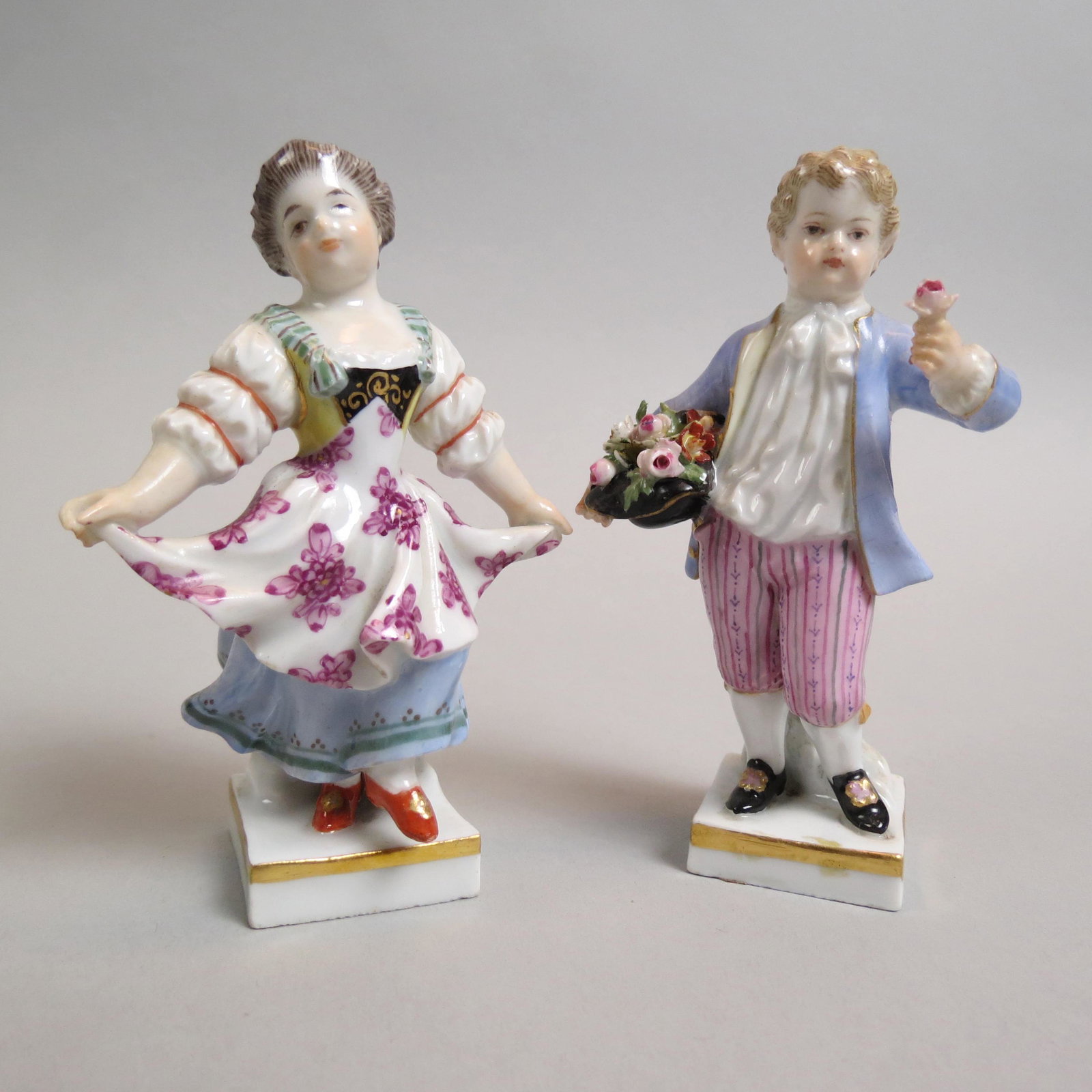 Pair of Meissen Porcelain Figurines of Boy & Girl,: him with basket of flowers, her weaaring a fancy apron, 4", crossed swords marks, excellent.
