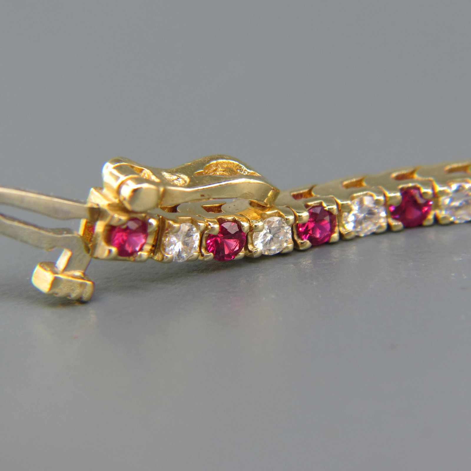 Ruby & Diamond Bracelet,: stright line style with 30 round diamonds totaling 1.28 carat and 30 round rubies totaling 1.92 carat in 14K yellow gold, high grade, with appraisal of $4,750.00