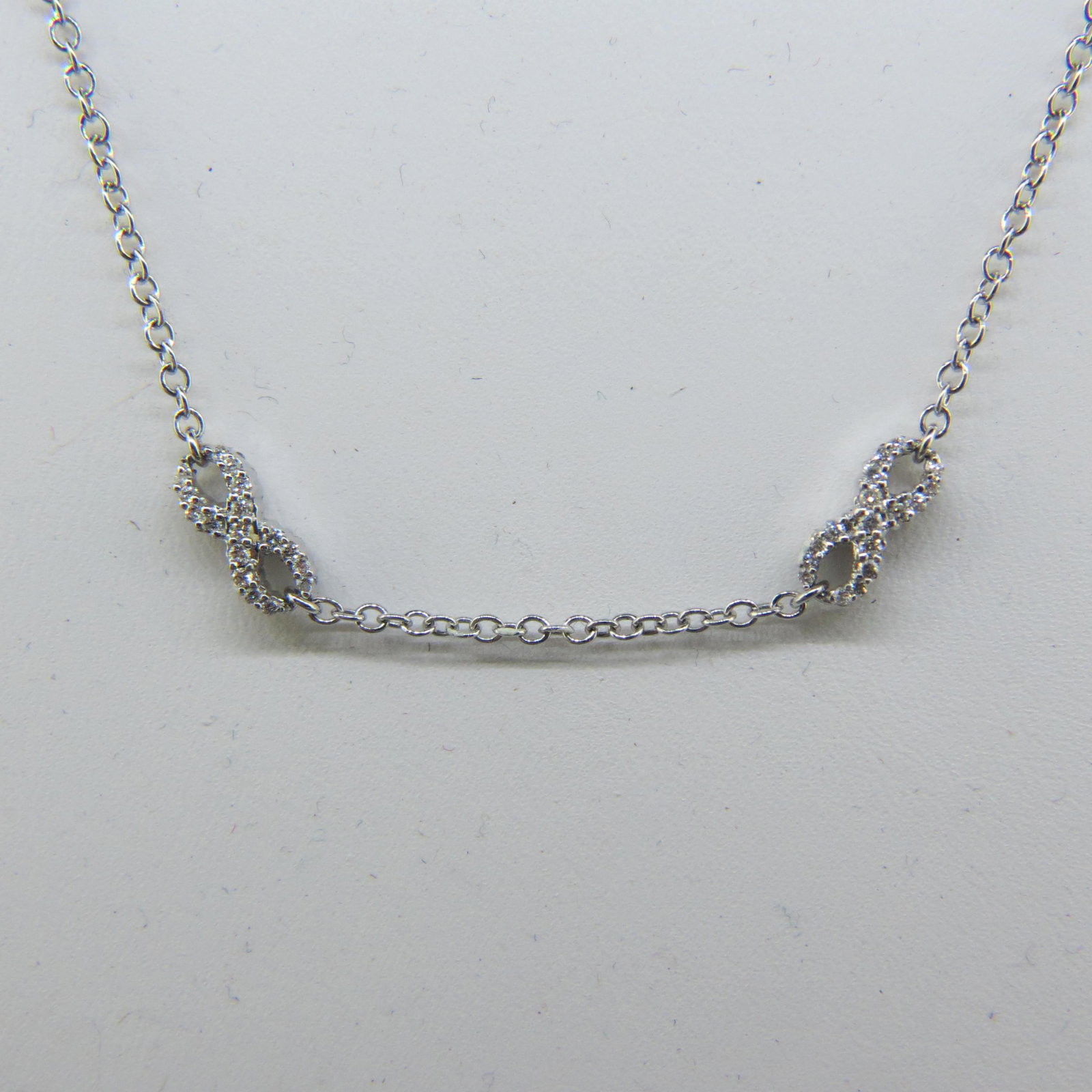 18K Gold & Diamond Necklace,: two love knot links with round diamonds total .40 carat, 18K white gold, 16 1/2" long, 5.1 grams.