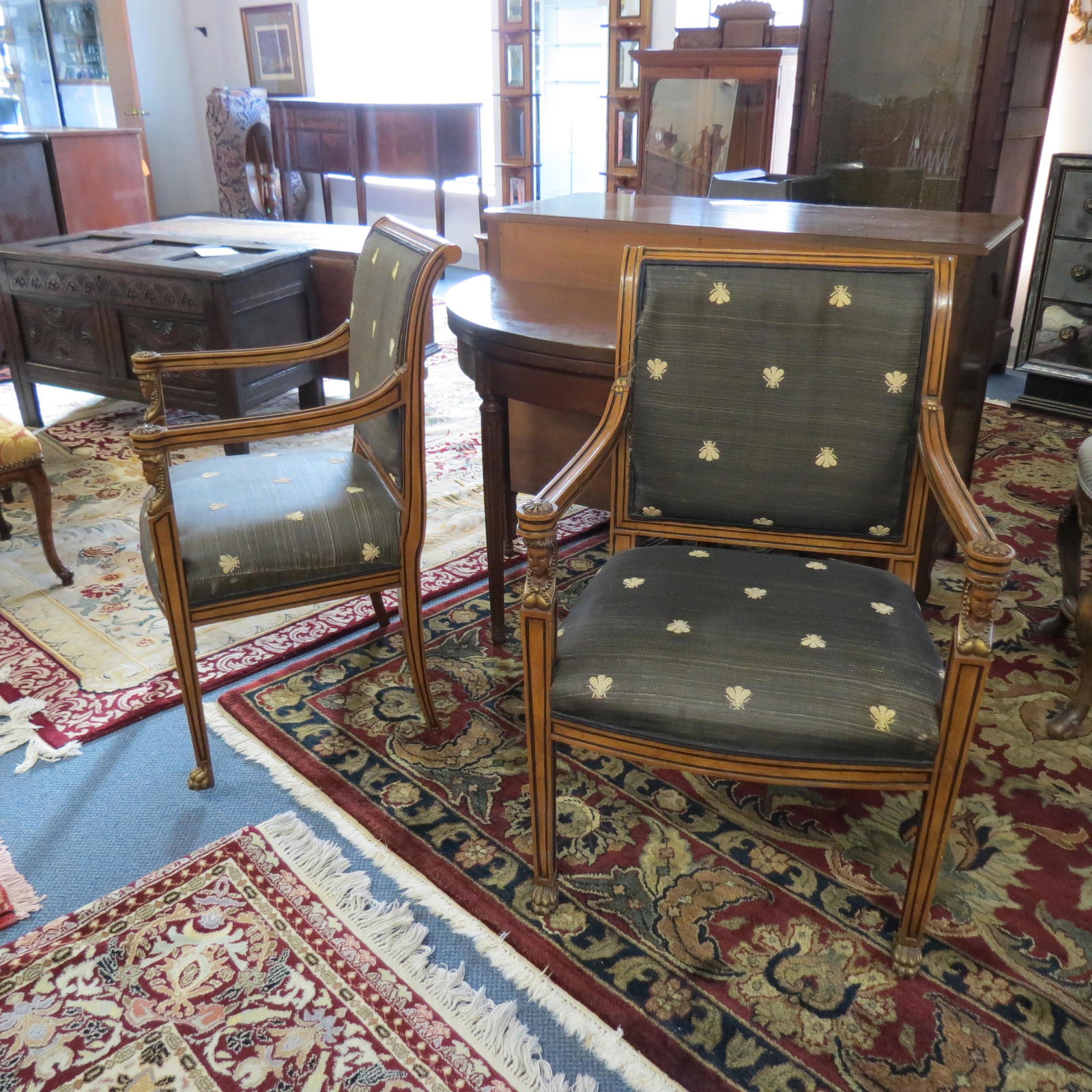 Pair of French Empire Style Arm Chairs,: carved sphinx heads and rosettes, sabre legs, claw feet, Napoleonic bee fabric.