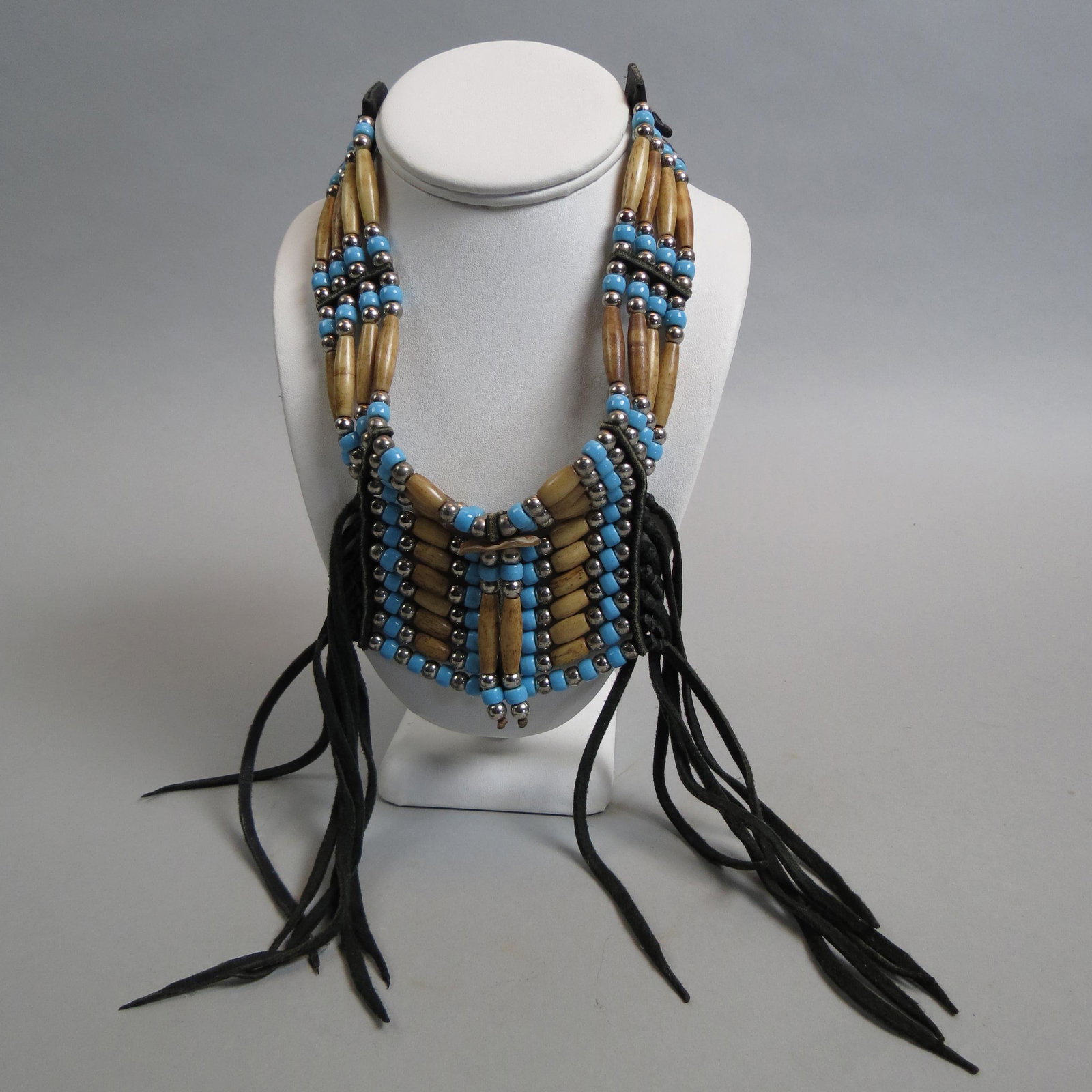 Indian Style Necklace,: carved bone, blue and silver beads on leather, up to 32" long, dangling tassel style.