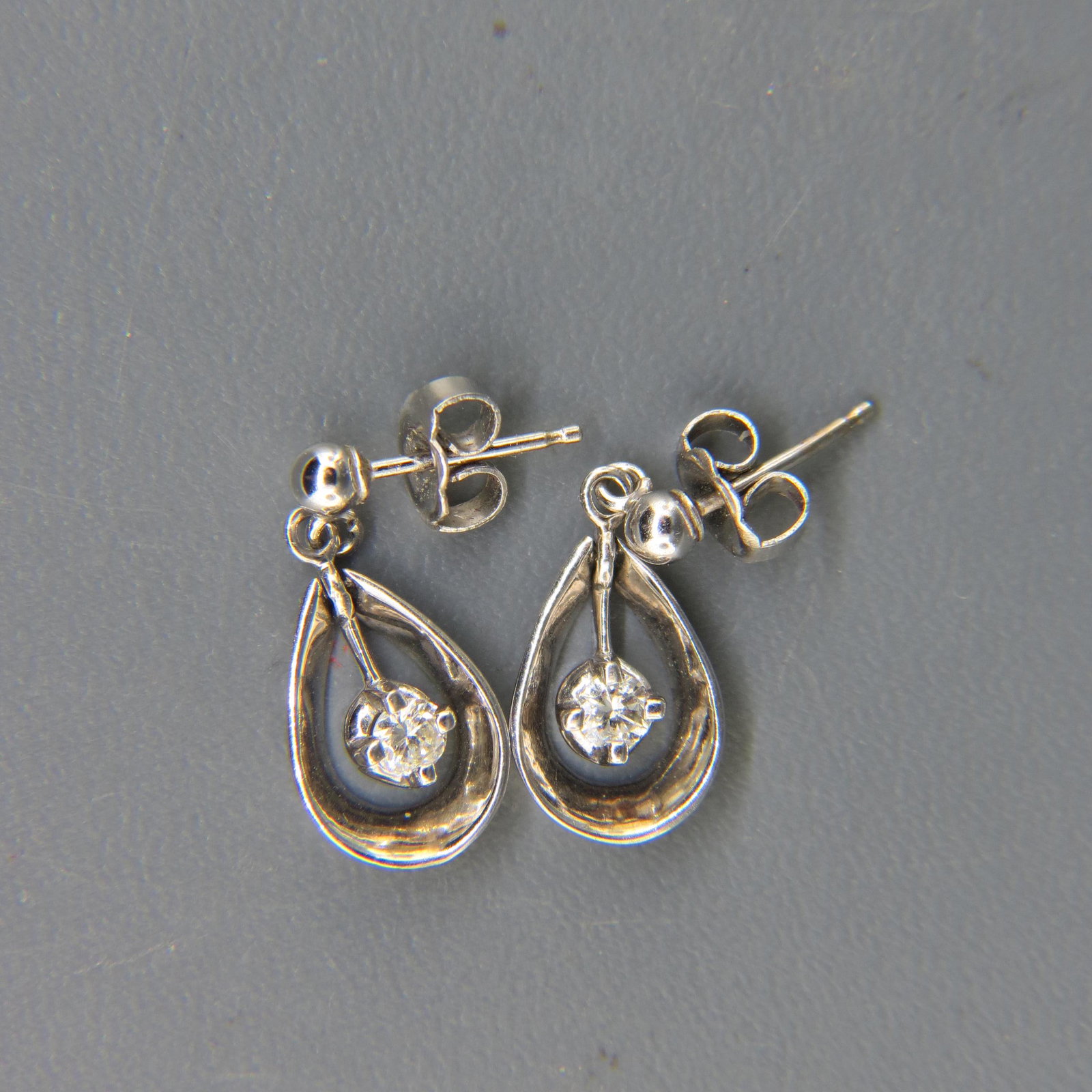 Diamond Earrings,: each with dangling .10 carat round diamond in 14K white gold teardrops, 3/4" long, 2.4 grams.