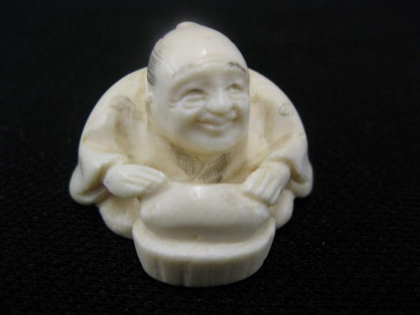 Carved Ivory Netsuke of Man with a Loaf of bread, : of bread, 1 3/8", signed.