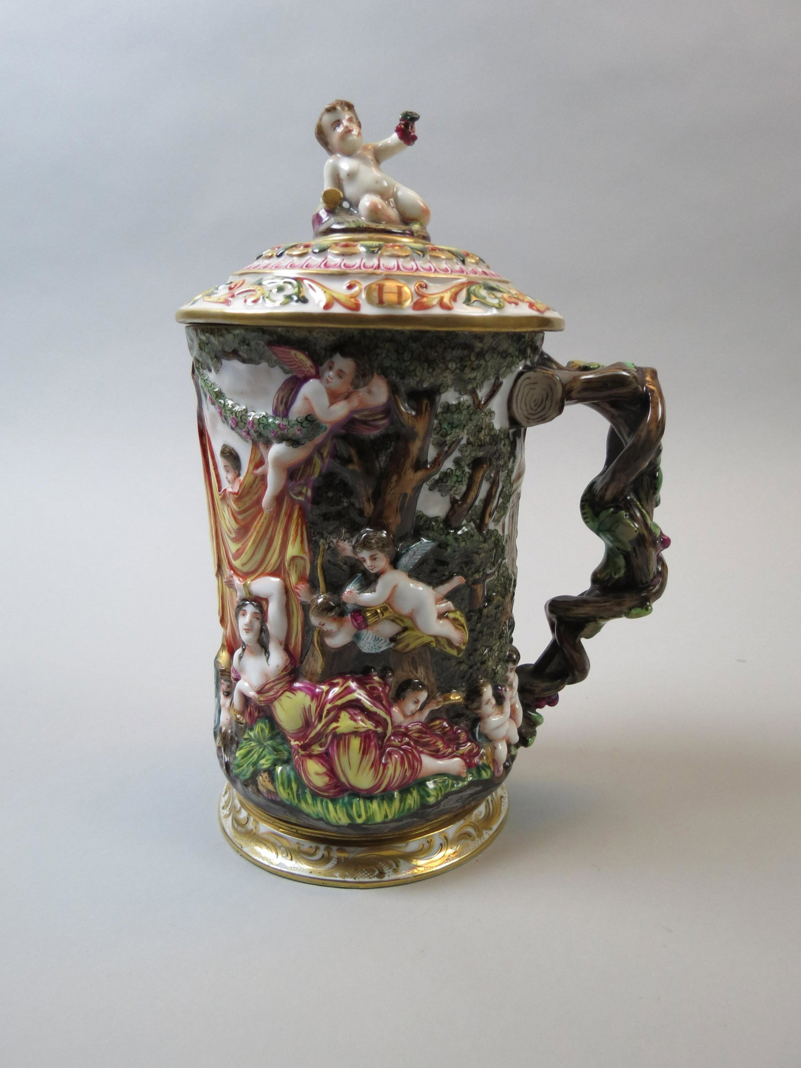 Early Capodimonte Porcelain Tankard or Stein: Semi-nude maiden and cherubs in the graden, figural children with grapes and wine goblets, grapevine handle, 10 1/2", excellent.