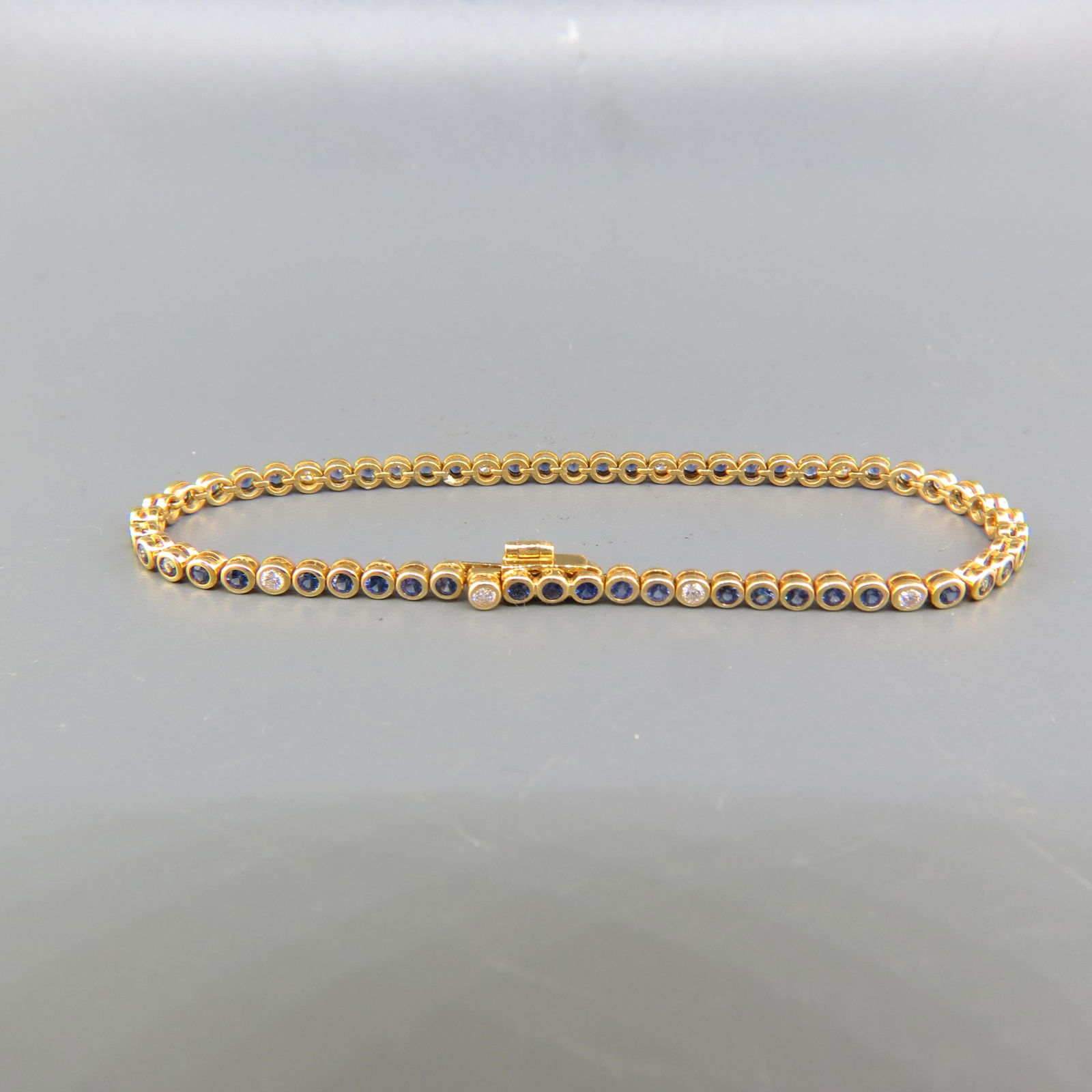 Sapphire & Diamond 18K Gold Bracelet: 50 Round rich blue sapphires totaling 2 carats and 10 round diamonds totaling .30 Carats in 18K yellow gold, high grade, with appraisal of $2,450.00, 6 3/4" Long.